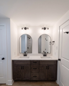 Completed bath with a double vanity and arched mirrors
