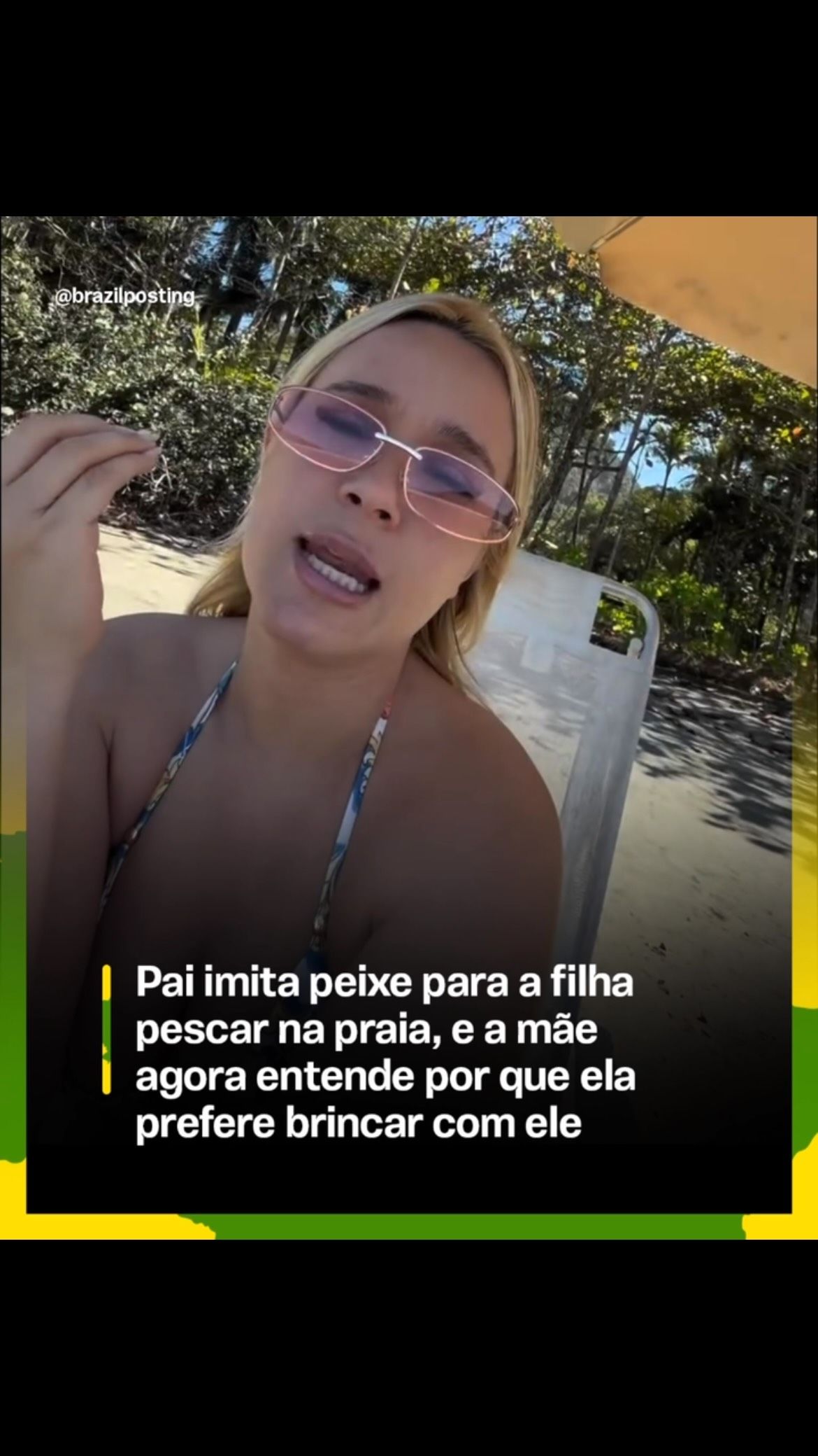 Mulher de óculos roxo em ambiente externo com vegetação ao fundo, sorrindo enquanto olha para a câmera em um dia ensolarado