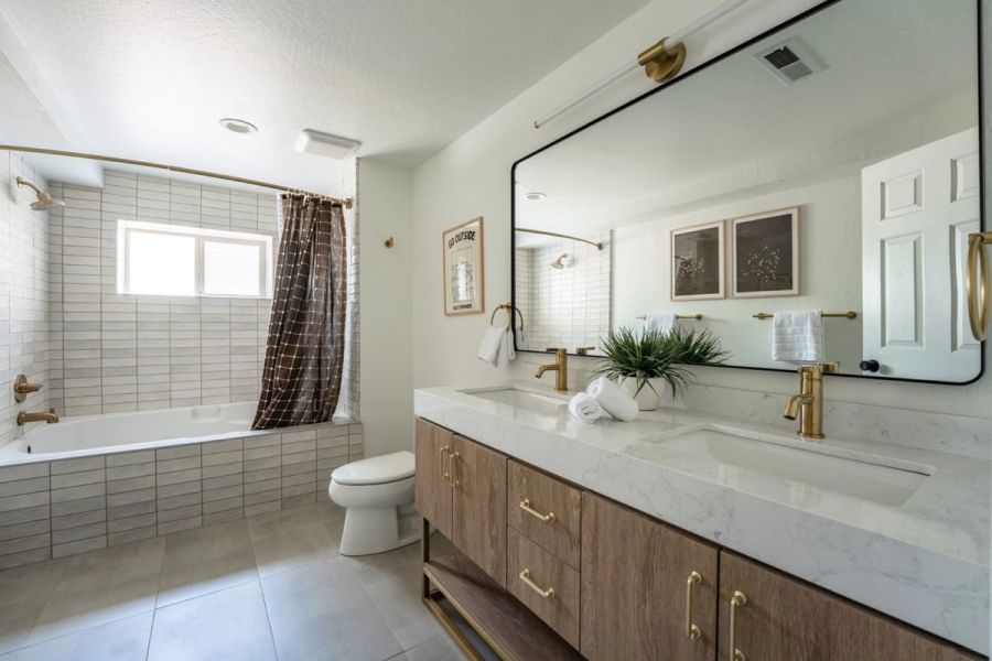 Lower-level bathroom with double vanity and tub