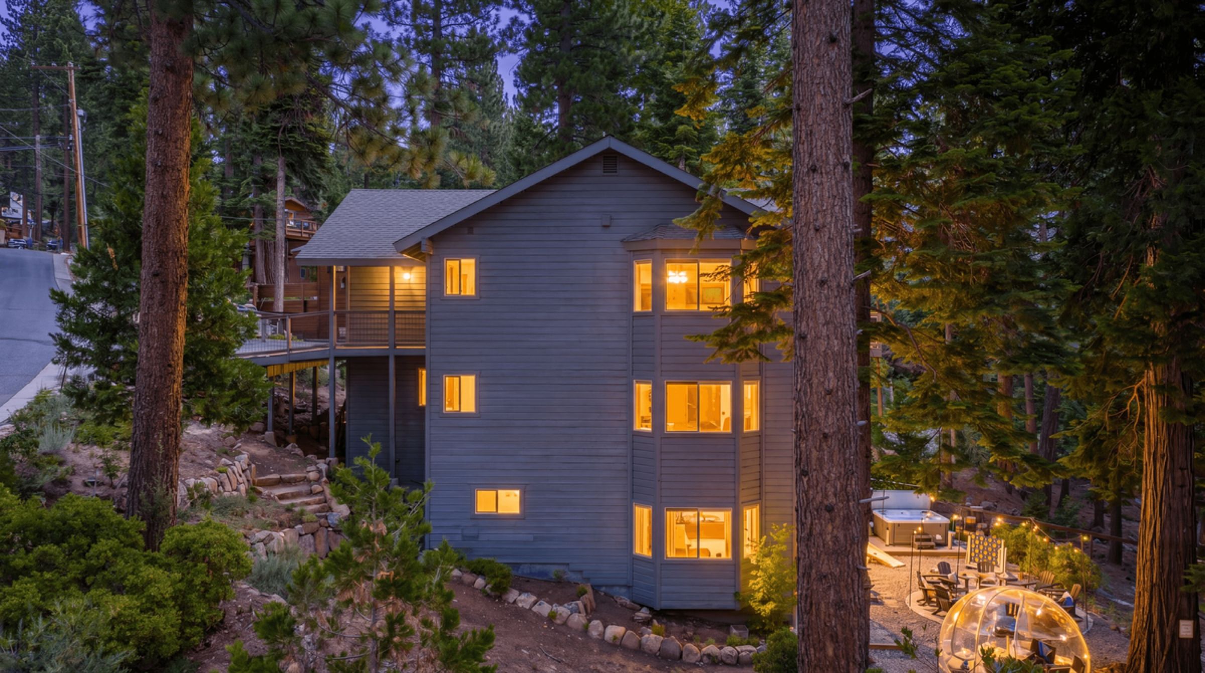 Starfall Lodge at dusk, windows glowing among the pines