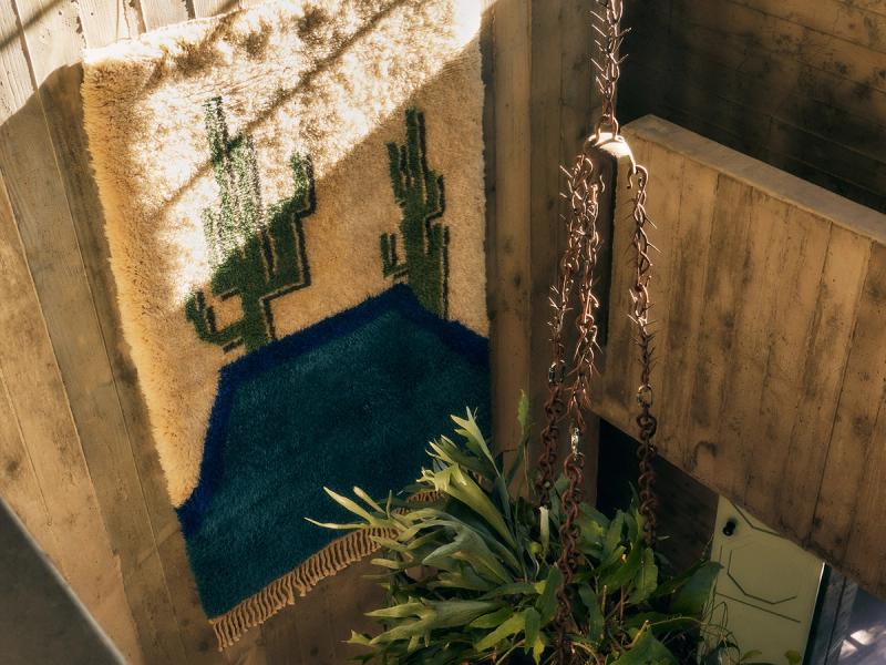 Cactus Pool rug hanging on wall. 