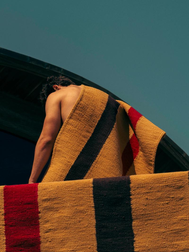 Male figure draped in rugs