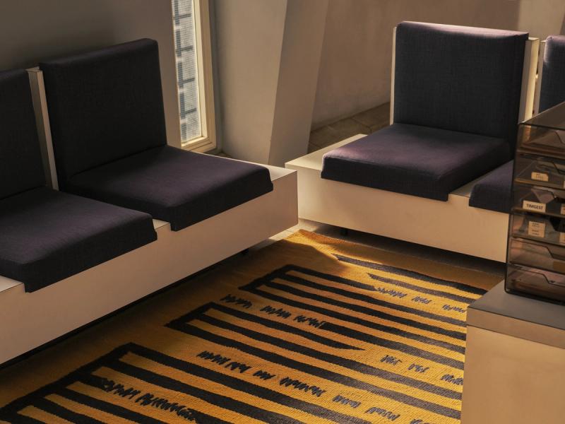 CEN-0124 rug on floor of office surrounded by white and blue seating