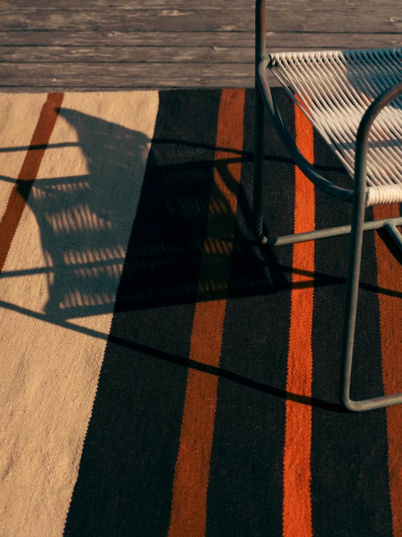 crop of striped rug with chair