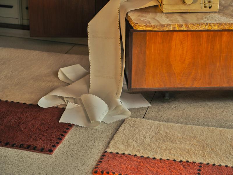 2 STA-0203 rugs on floor with pile of papers