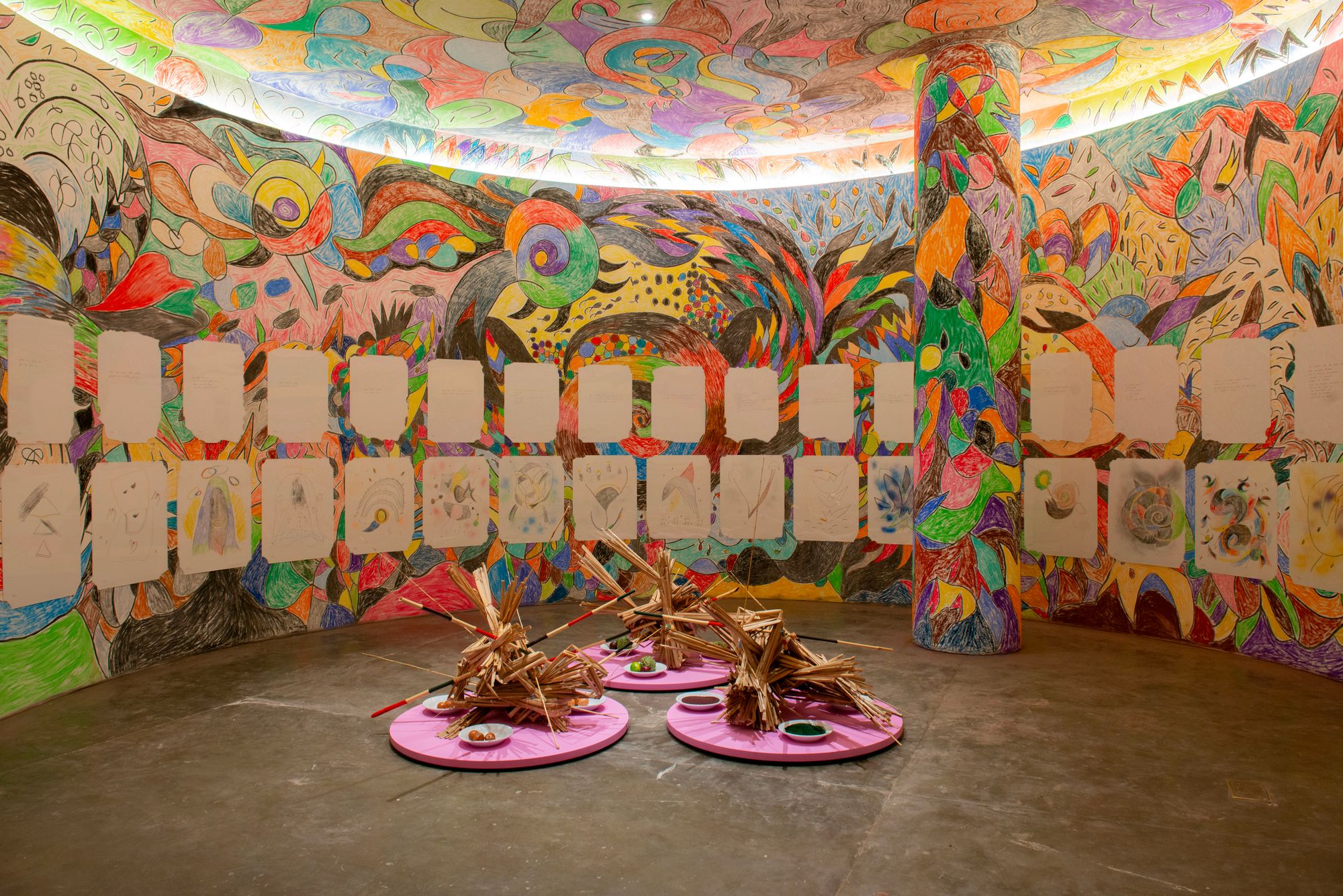 A colorful room where the walls and celing are rounded and covered in vibrant designs.