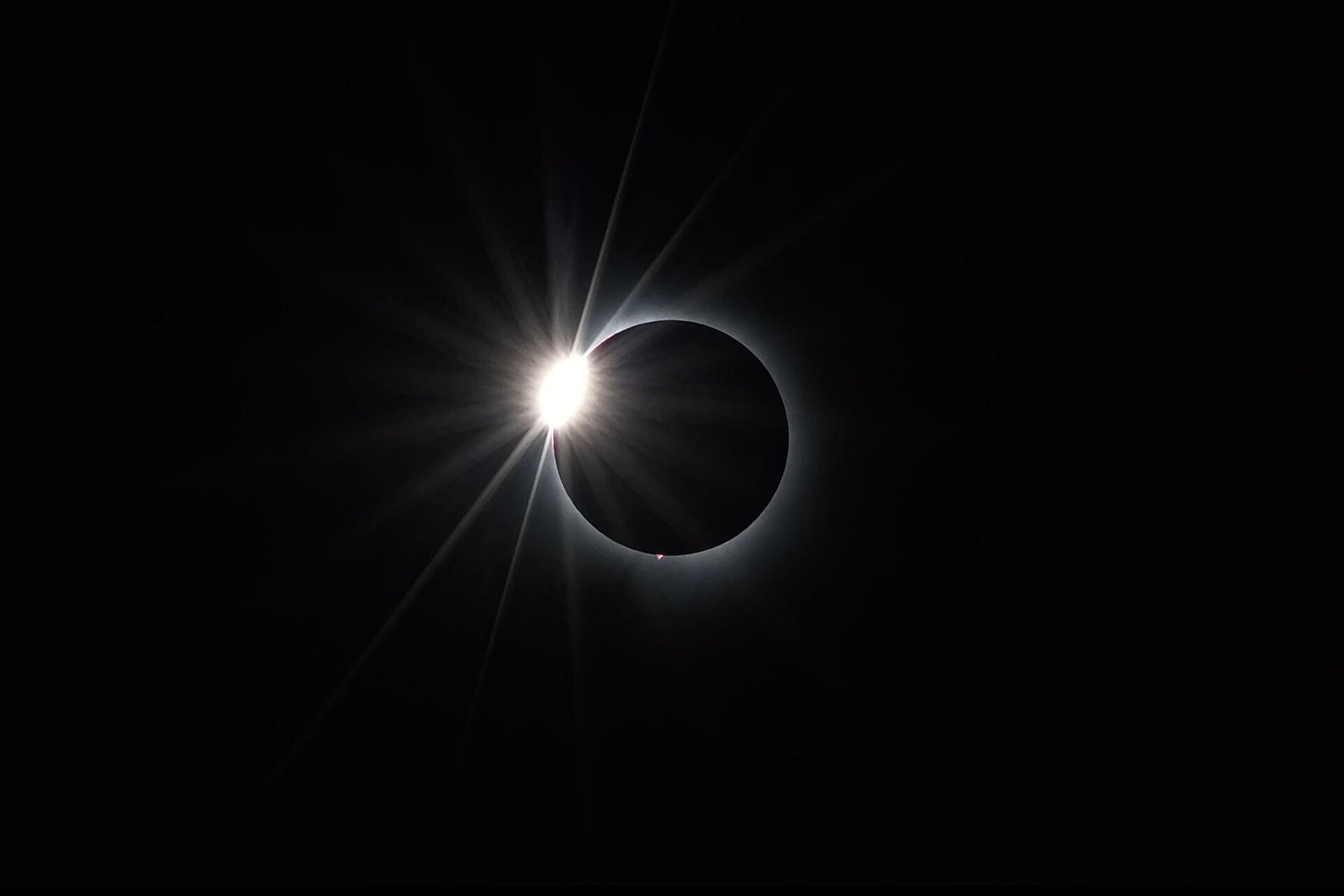 Black backdrop and black circle with thin white outline, and to the left, of the circle a shining spot.