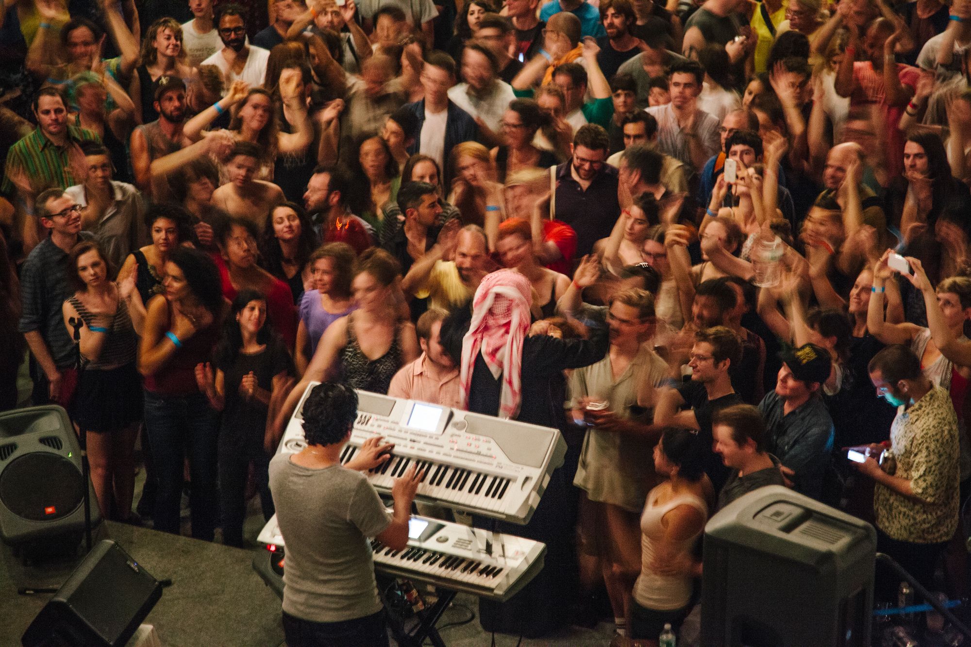 A crowd dancing to a DJ