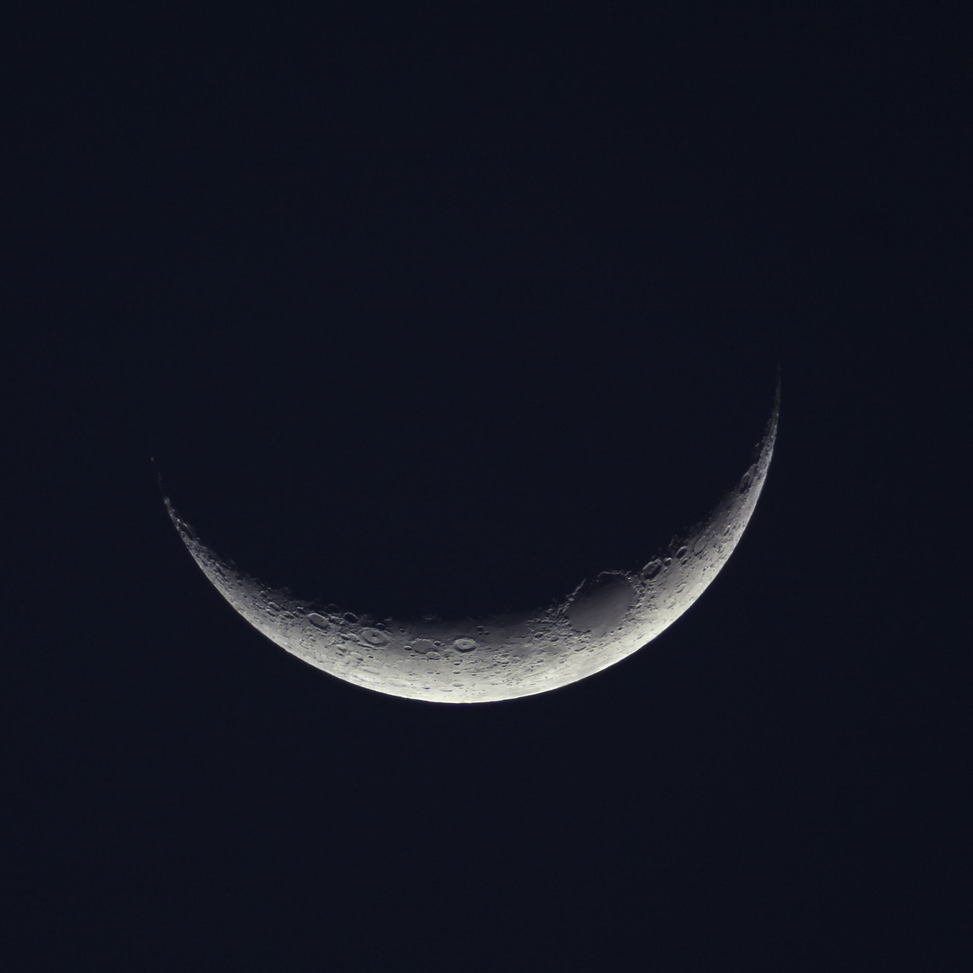A close-up photograph of the crescent moon against the black nightsky.