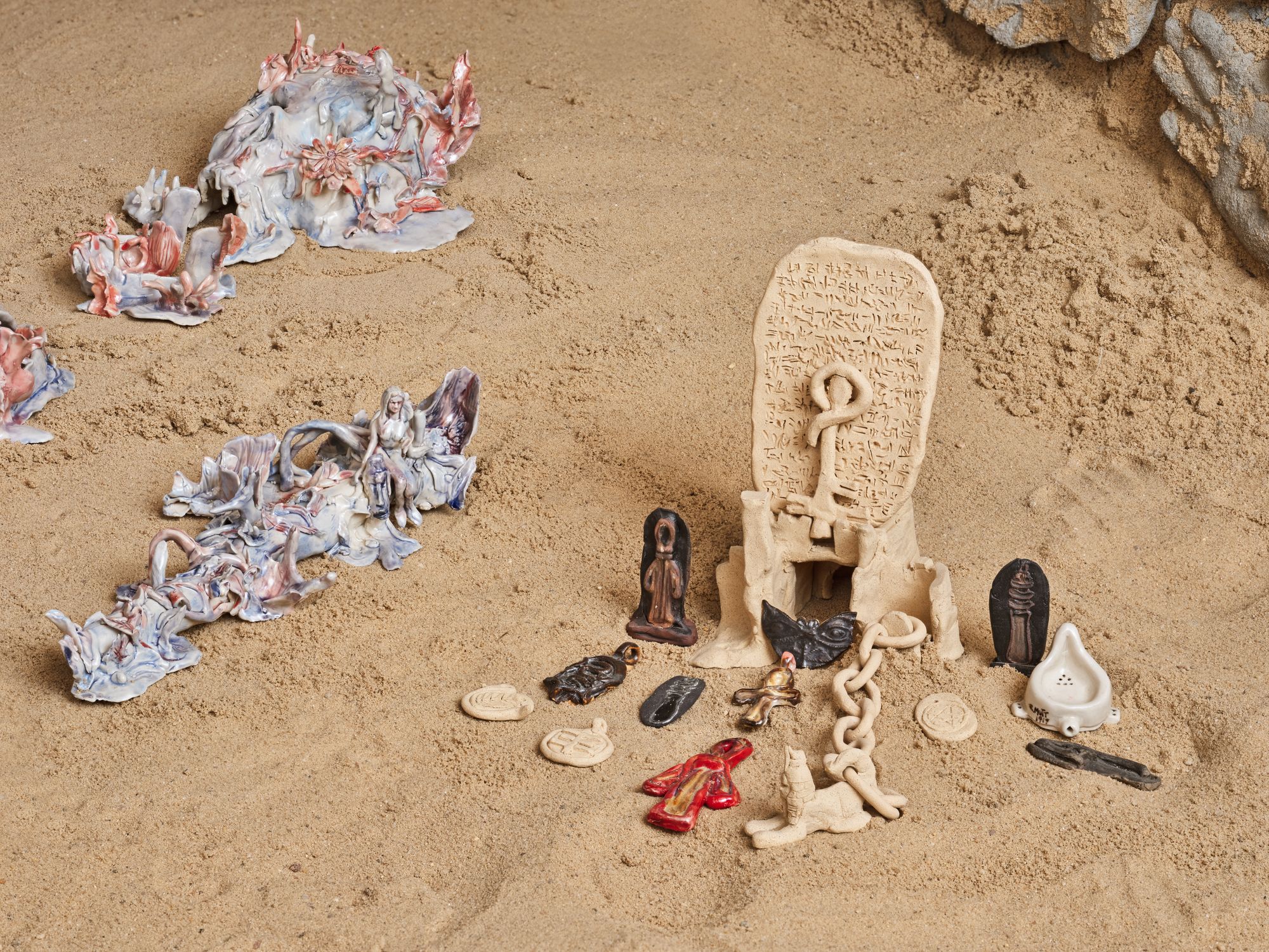 A collection of small ceramic objects resting on a sandy floor.