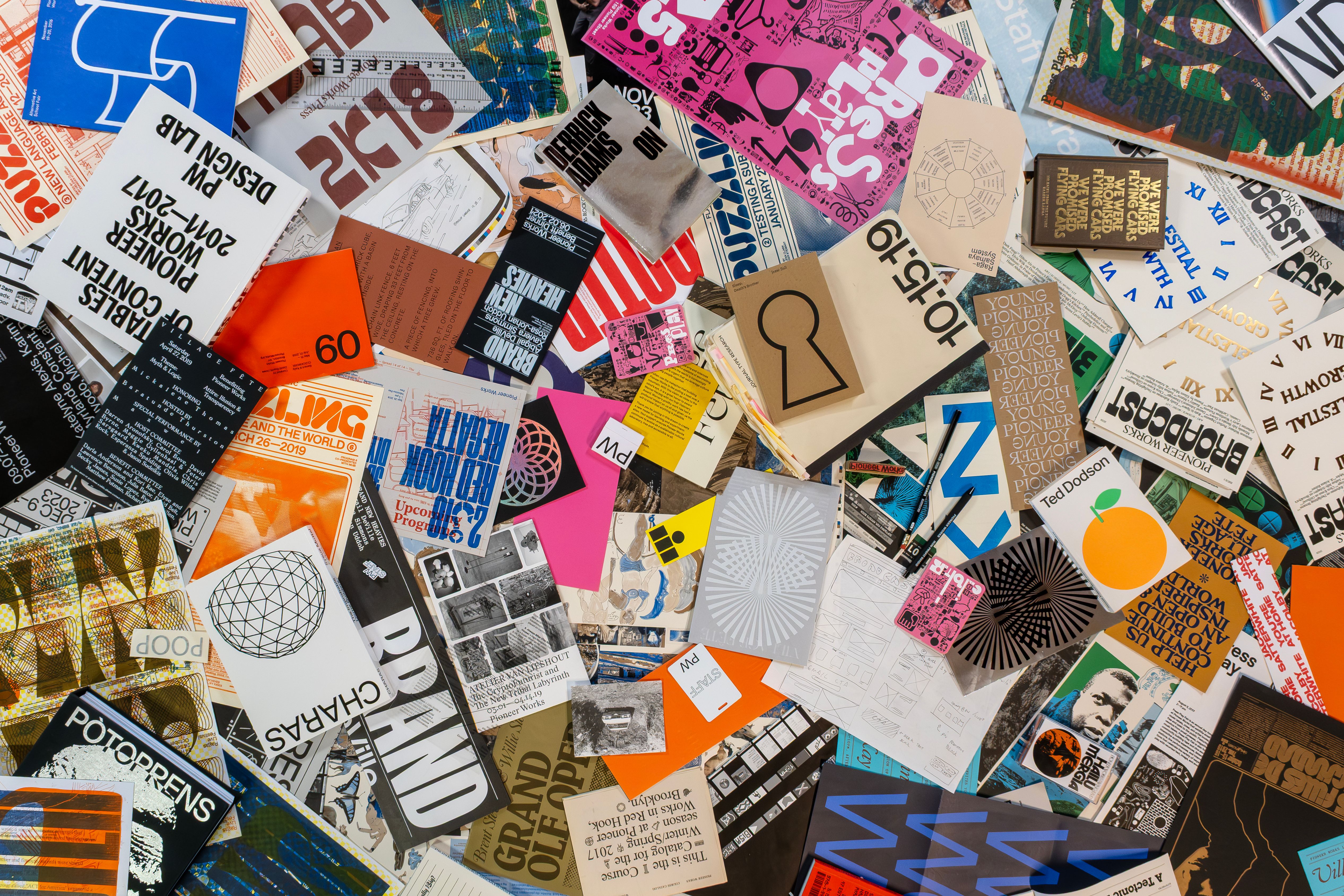 A table full of magazines, clippings, and programs from the Pioneer Works archives