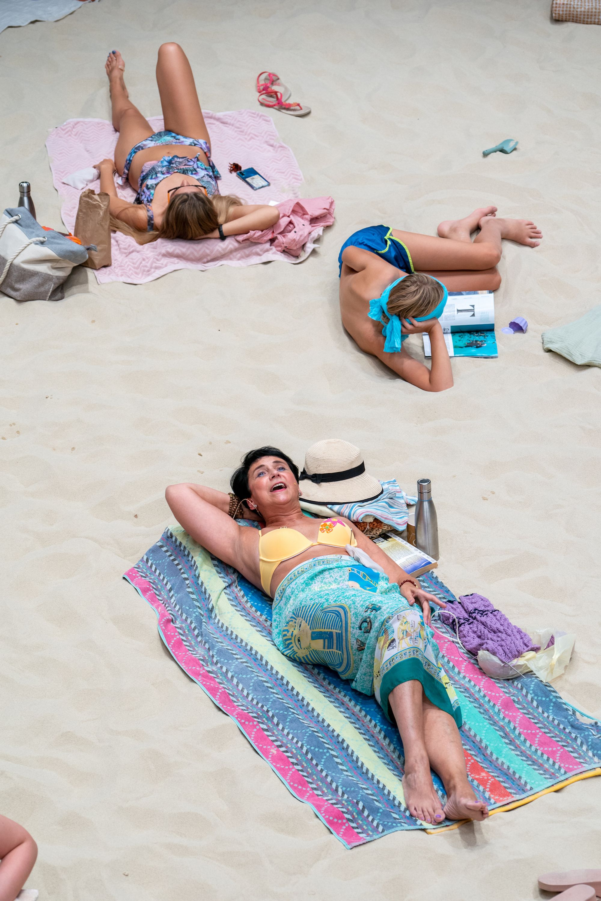 A lady reclining on a beach towel