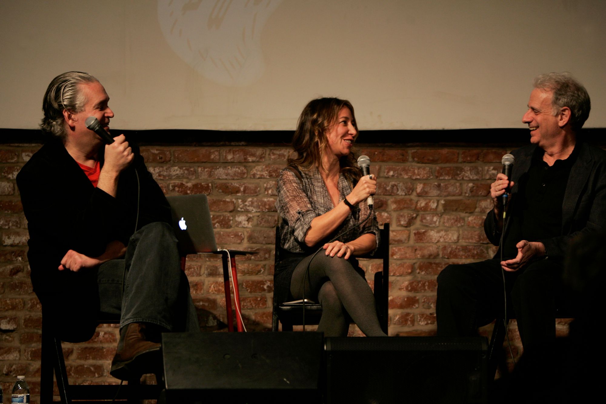 Three people sitting on stage having a conversation