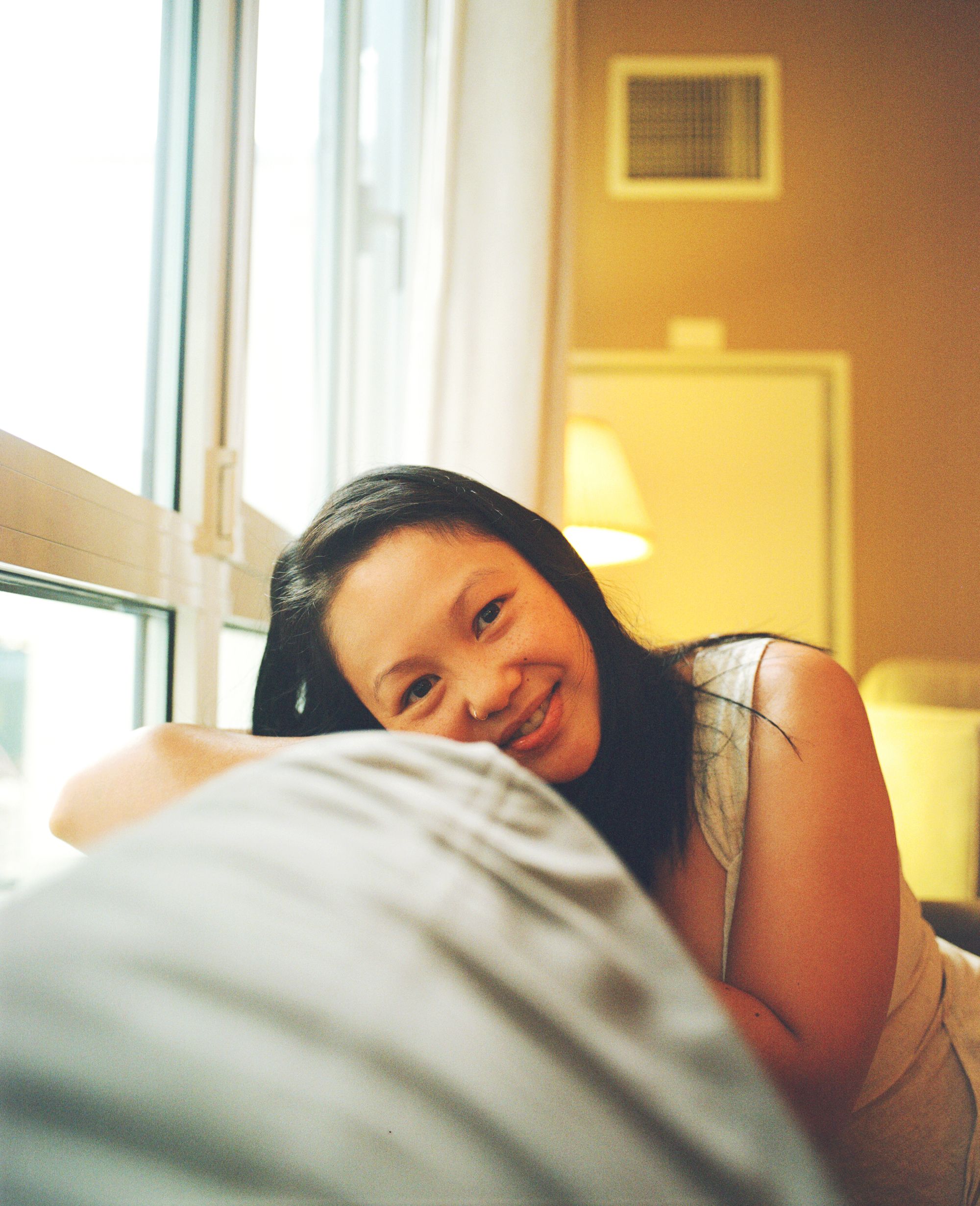 Emily Yuen leans against cushion, smiling 