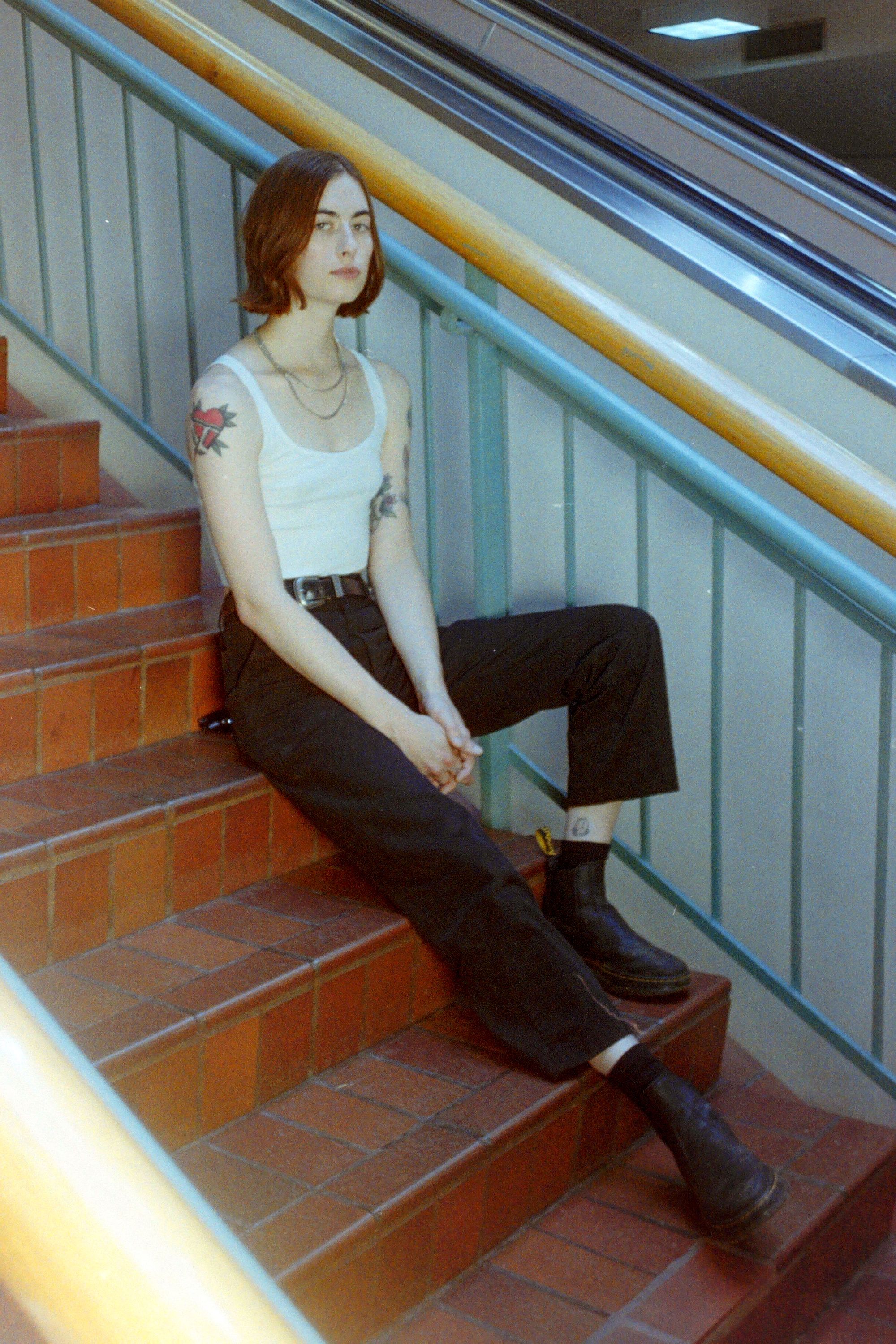 white woman sitting on stairs and looking at camera