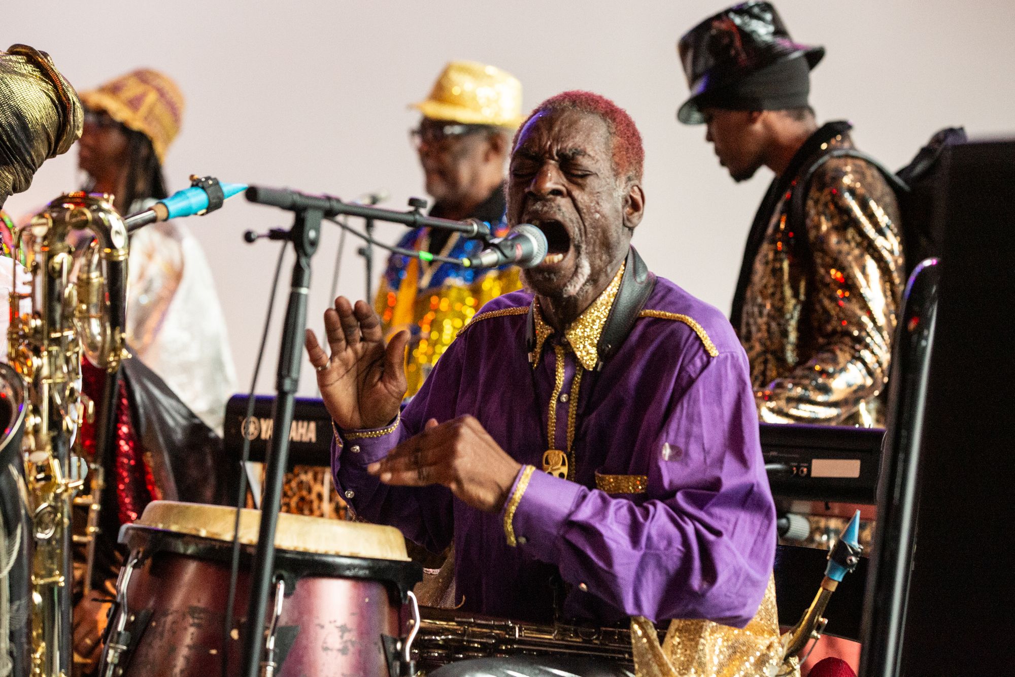 Marshall Allen performing at Pioneer Works with his back turned to an audience full of listeners.