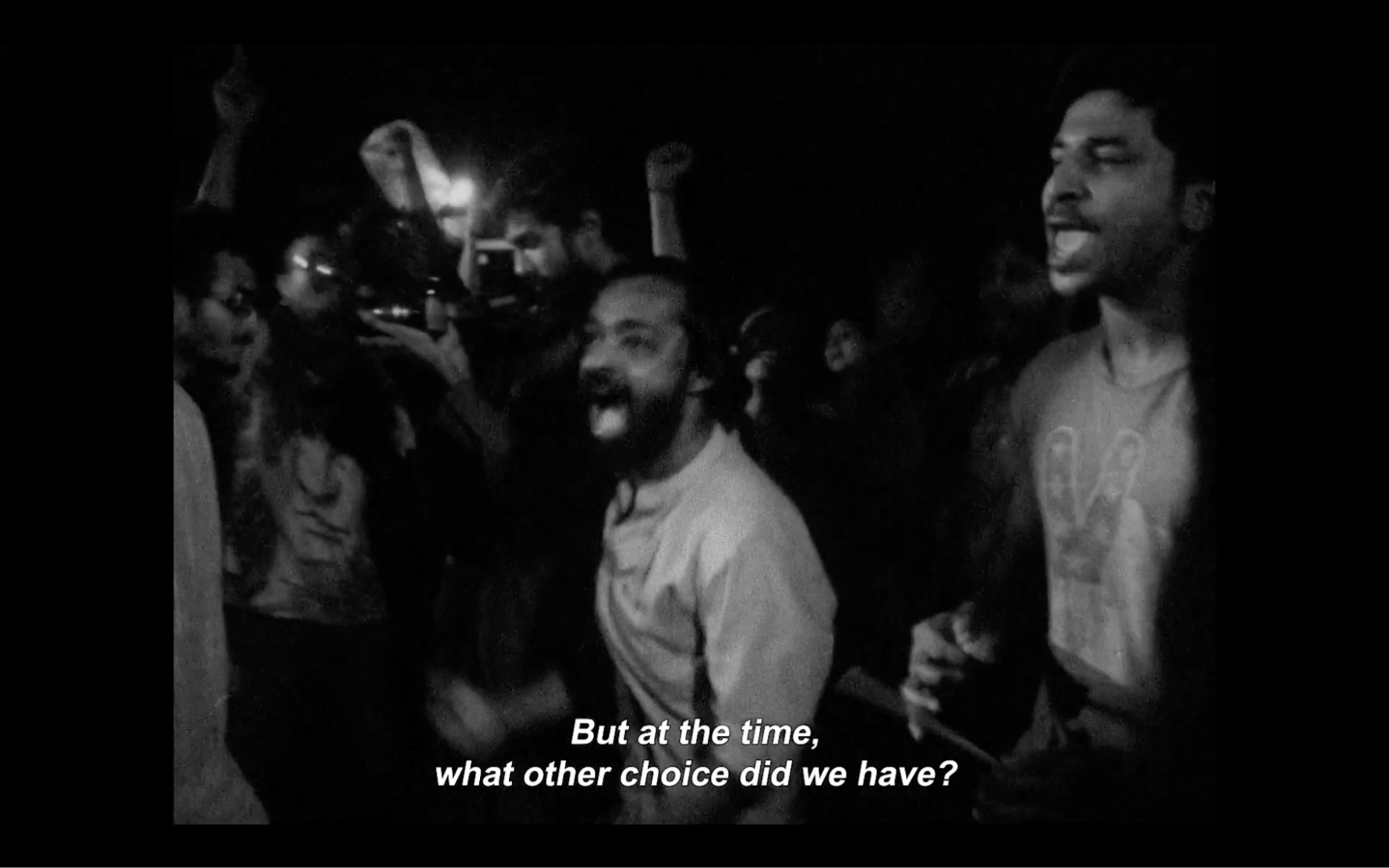 A black and white image from the film where people are yelling, with the caption "But at the time, what other choice did we have?"