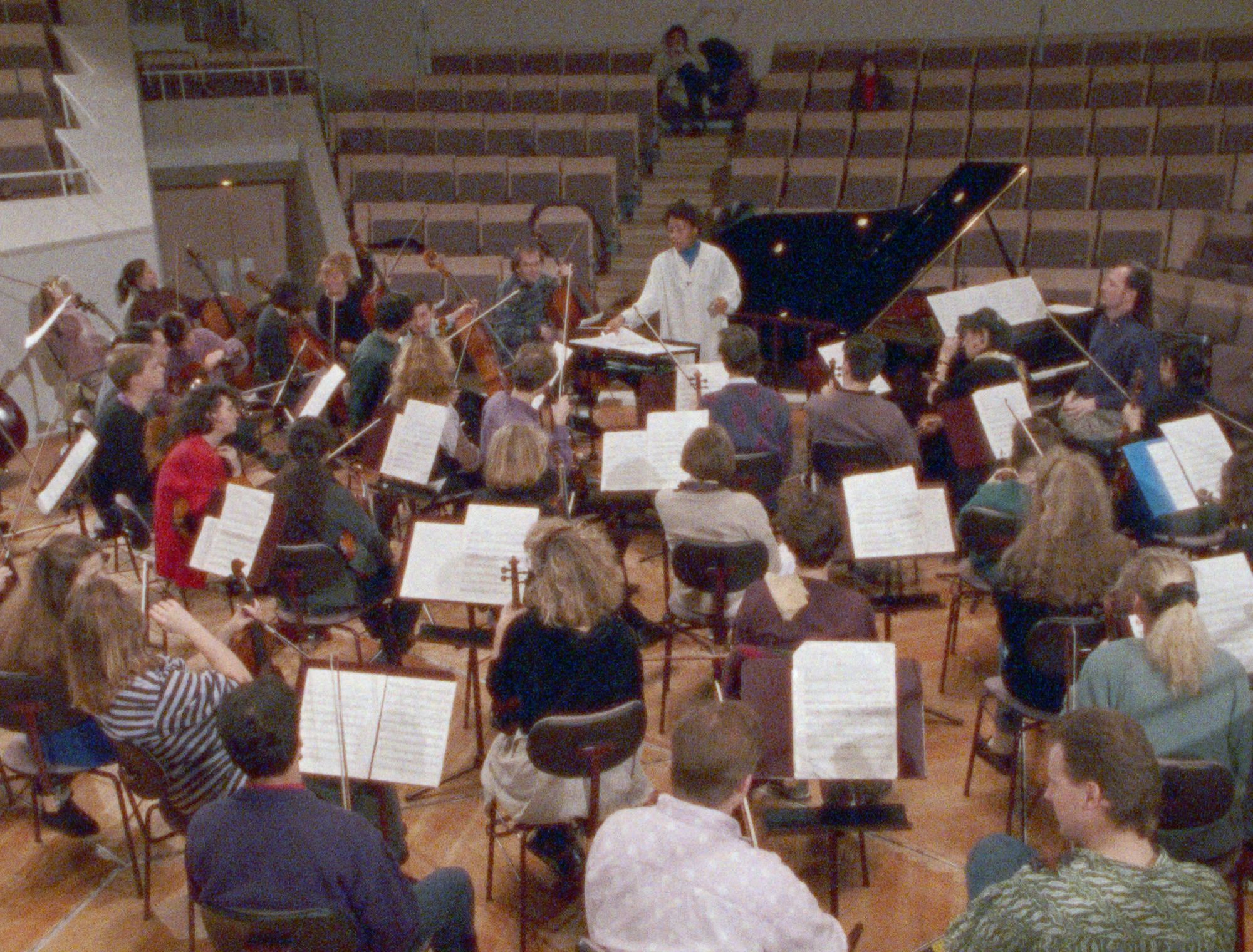 A big group of people rehearse together with instruments.