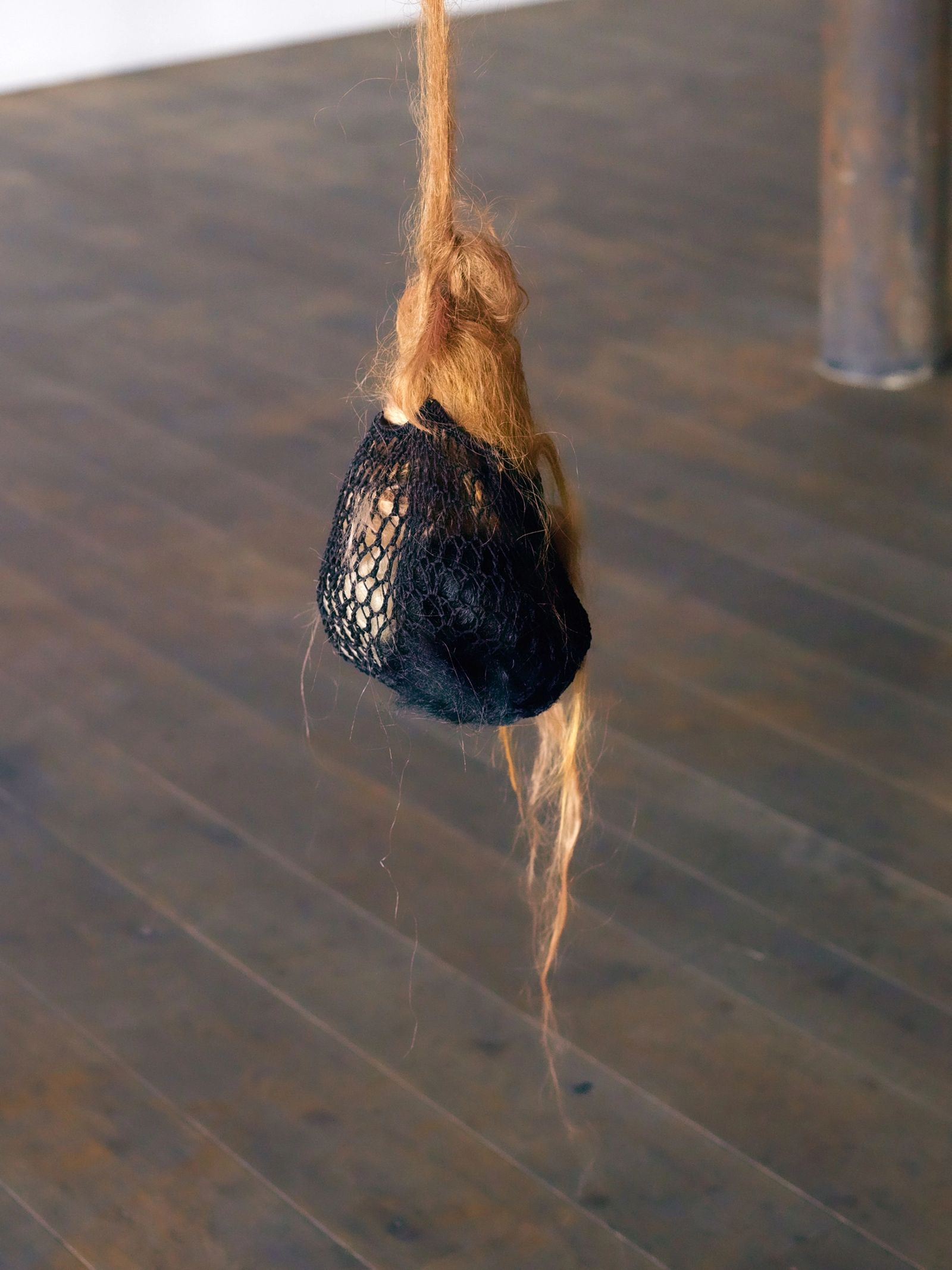 A hair work that looks like a black net stuffed with brown hair