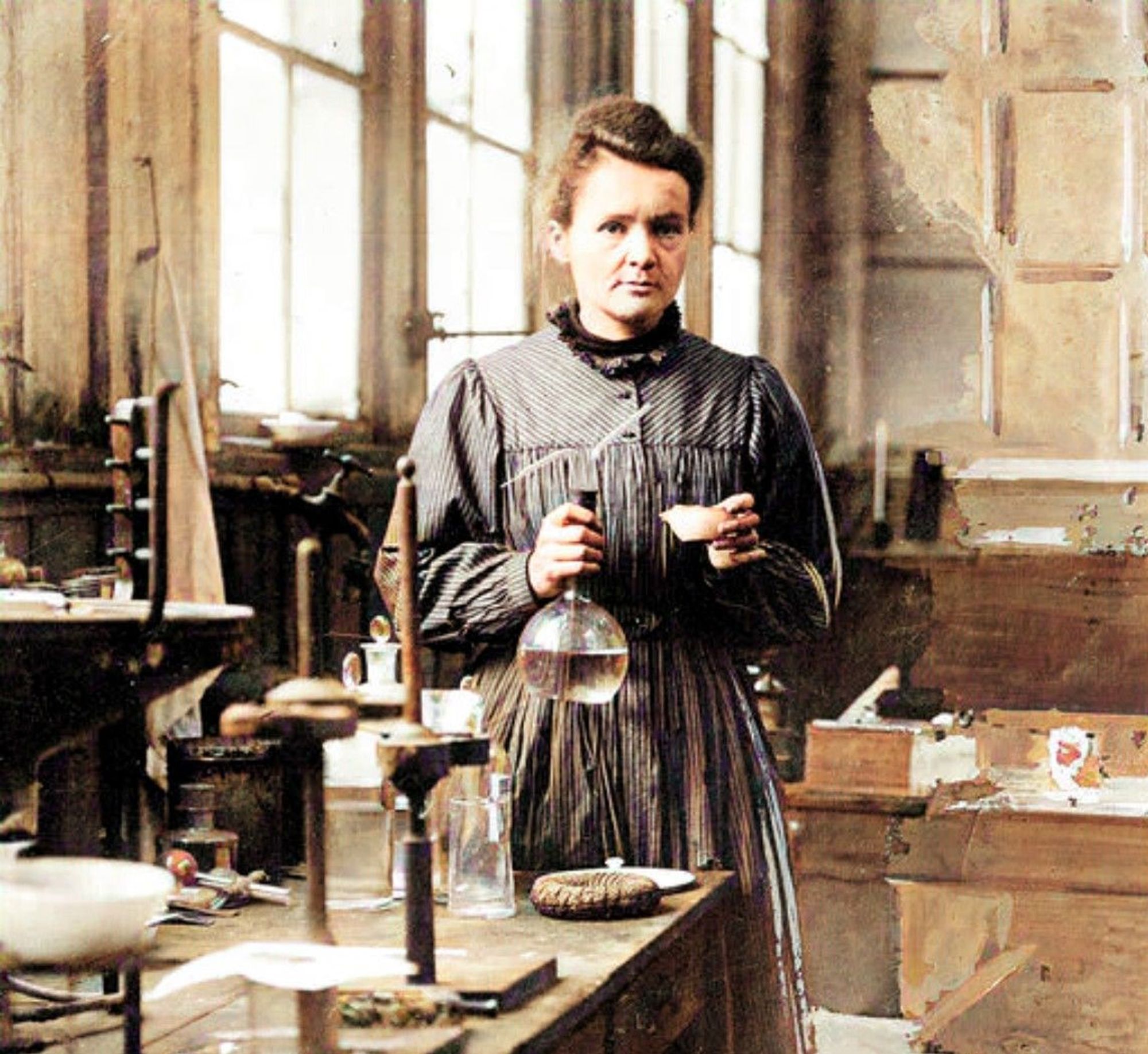 Colorized portrait of Marie Curie holding scientific glasses