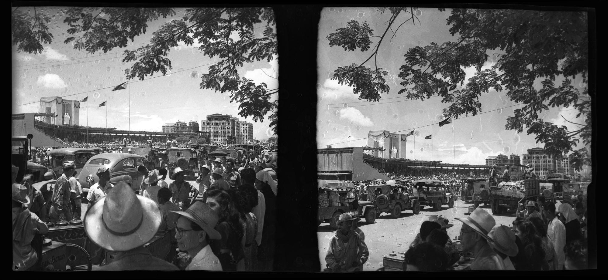 A black-and-white dyptich photograph that depicts the ceremony that celebrates the end of US colonization of the Philippine Islands on July 4, 1946. The photograph is taken from within the crowd, who are in the foreground looking out into the ceremony.