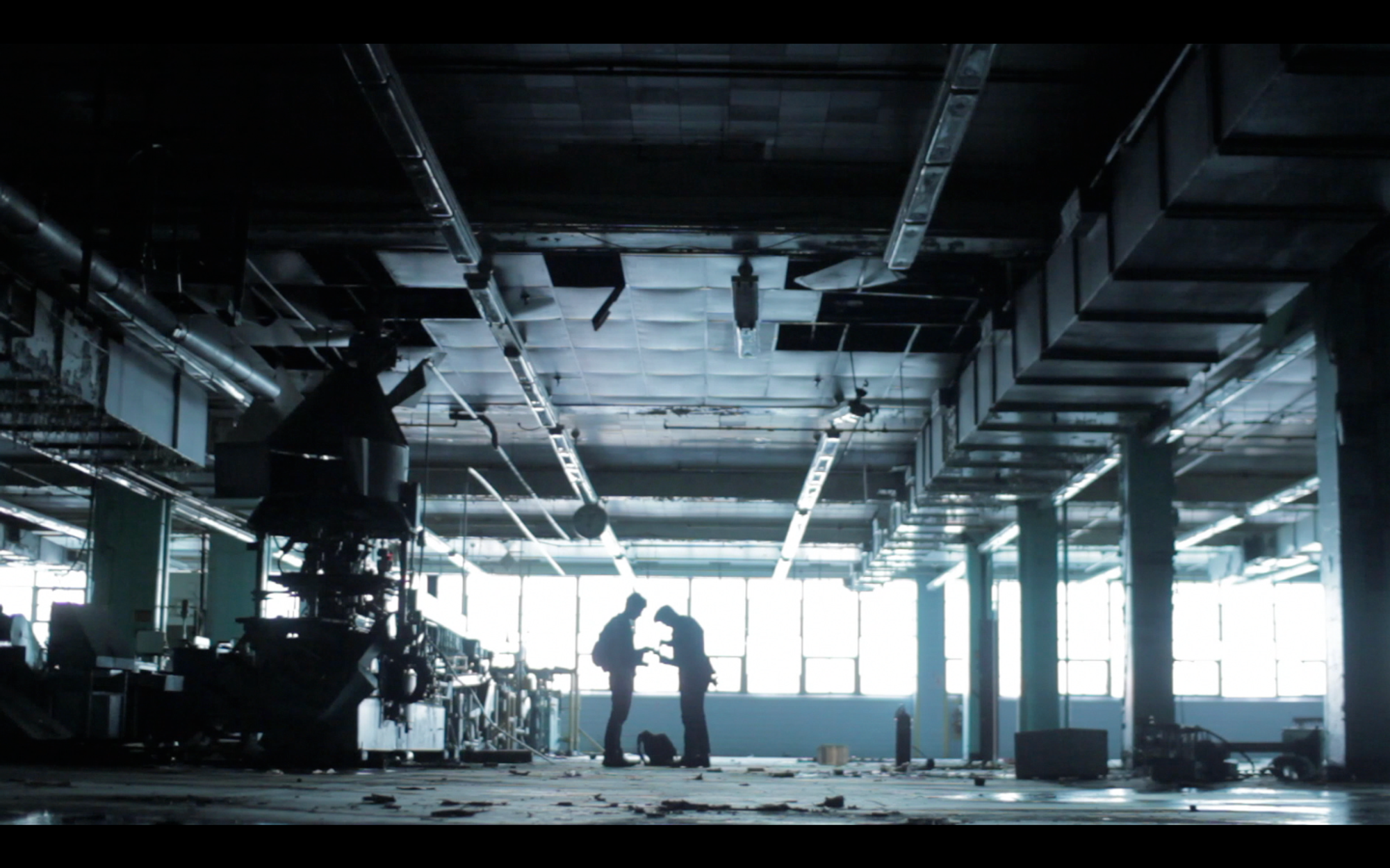 Two people standing in an empty warehouse