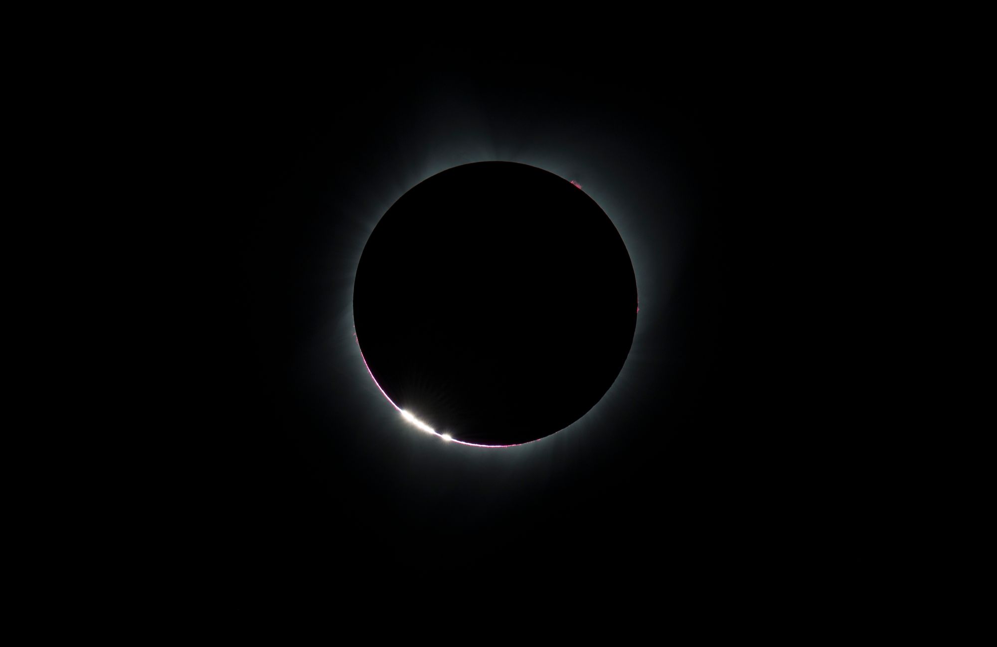 An eclipsed sun with Baily's Beads visible around the edges