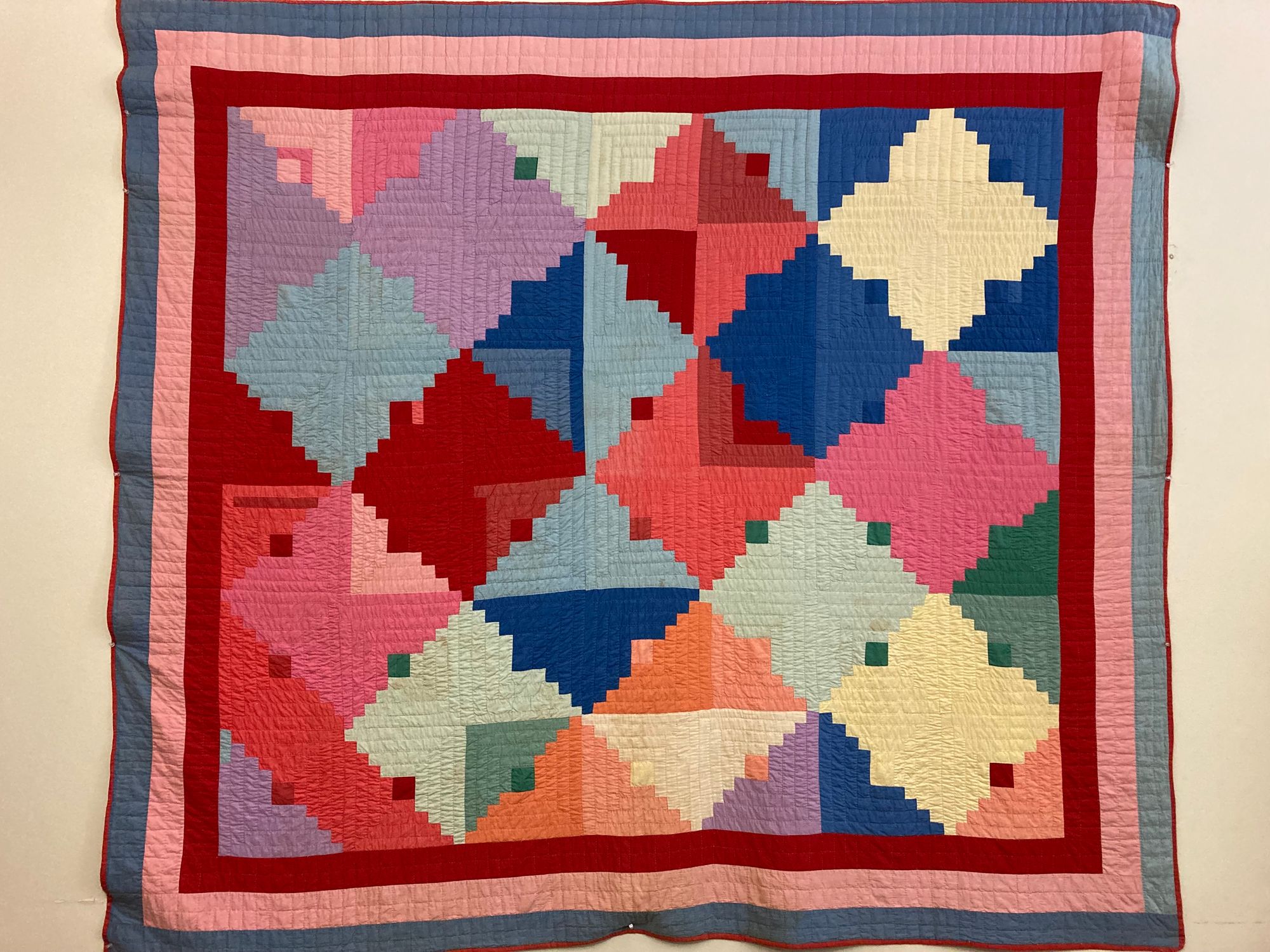 A colorful quilt hanging on a wall