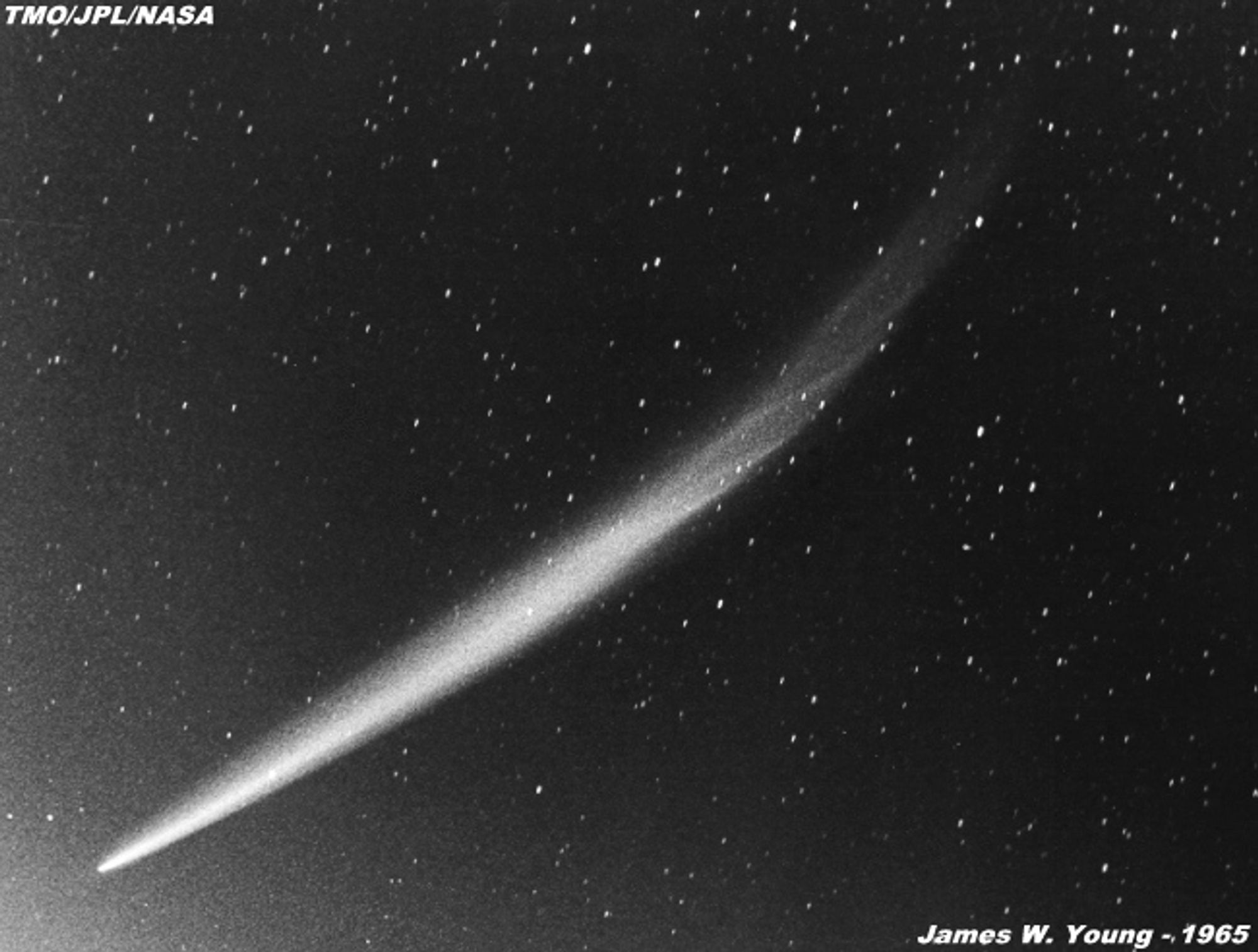 Black sky with scattered stars; comet streak cuts across in a curve from right-left.