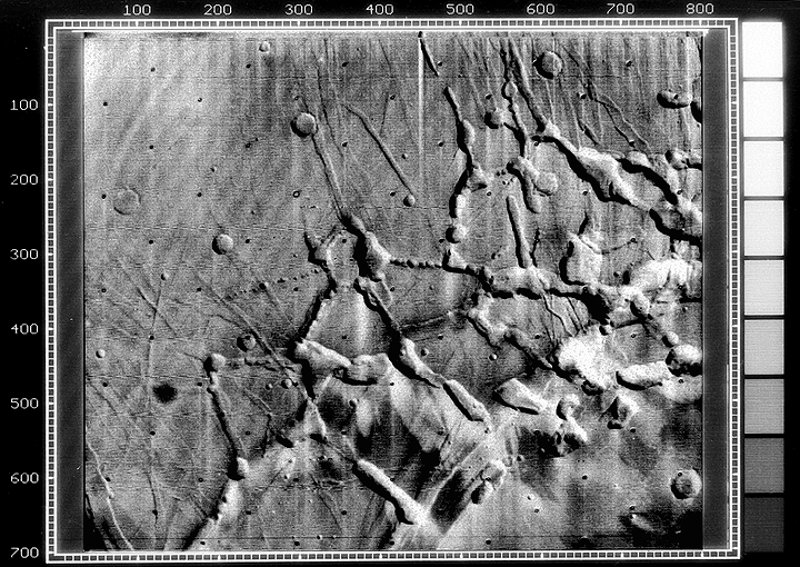 Black and white photo of the linear graben, grooves, and crater chains on Mars