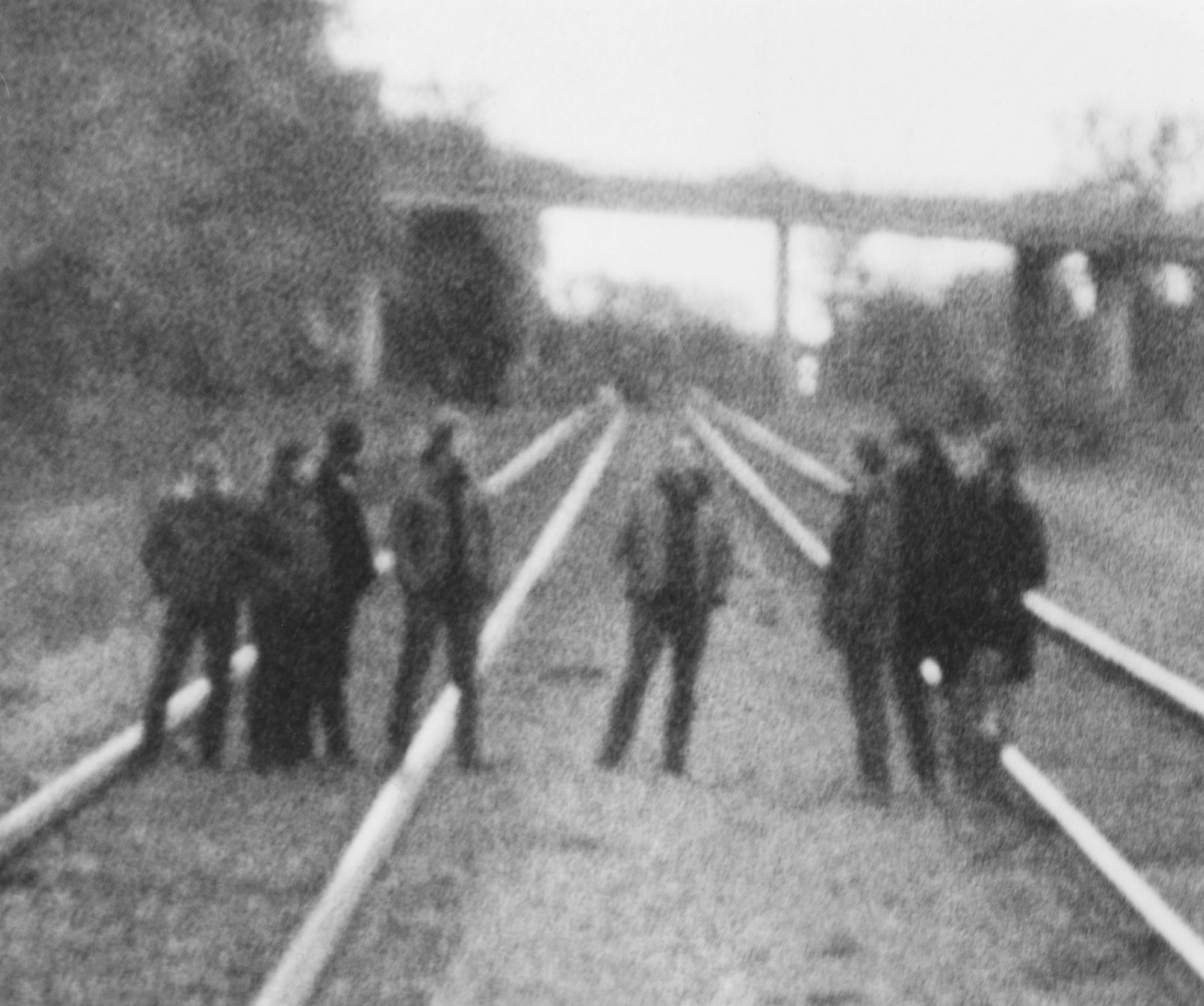 Blurry image of Godspeed You! on train tracks