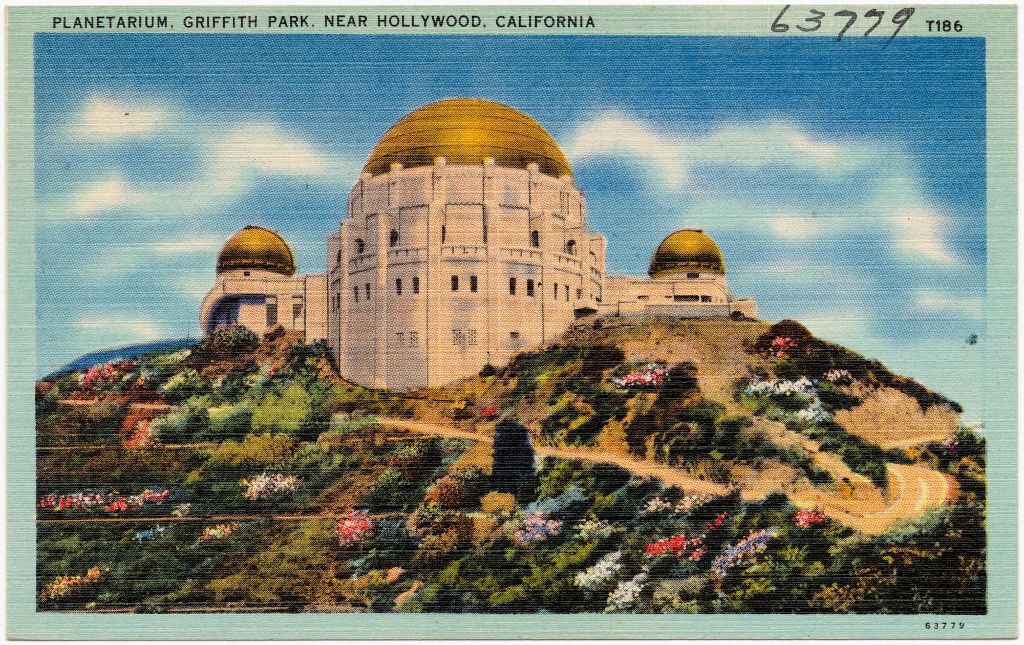 A postcard featuring Griffith Park Planetarium on a hill covered in shrubbery and flowers.