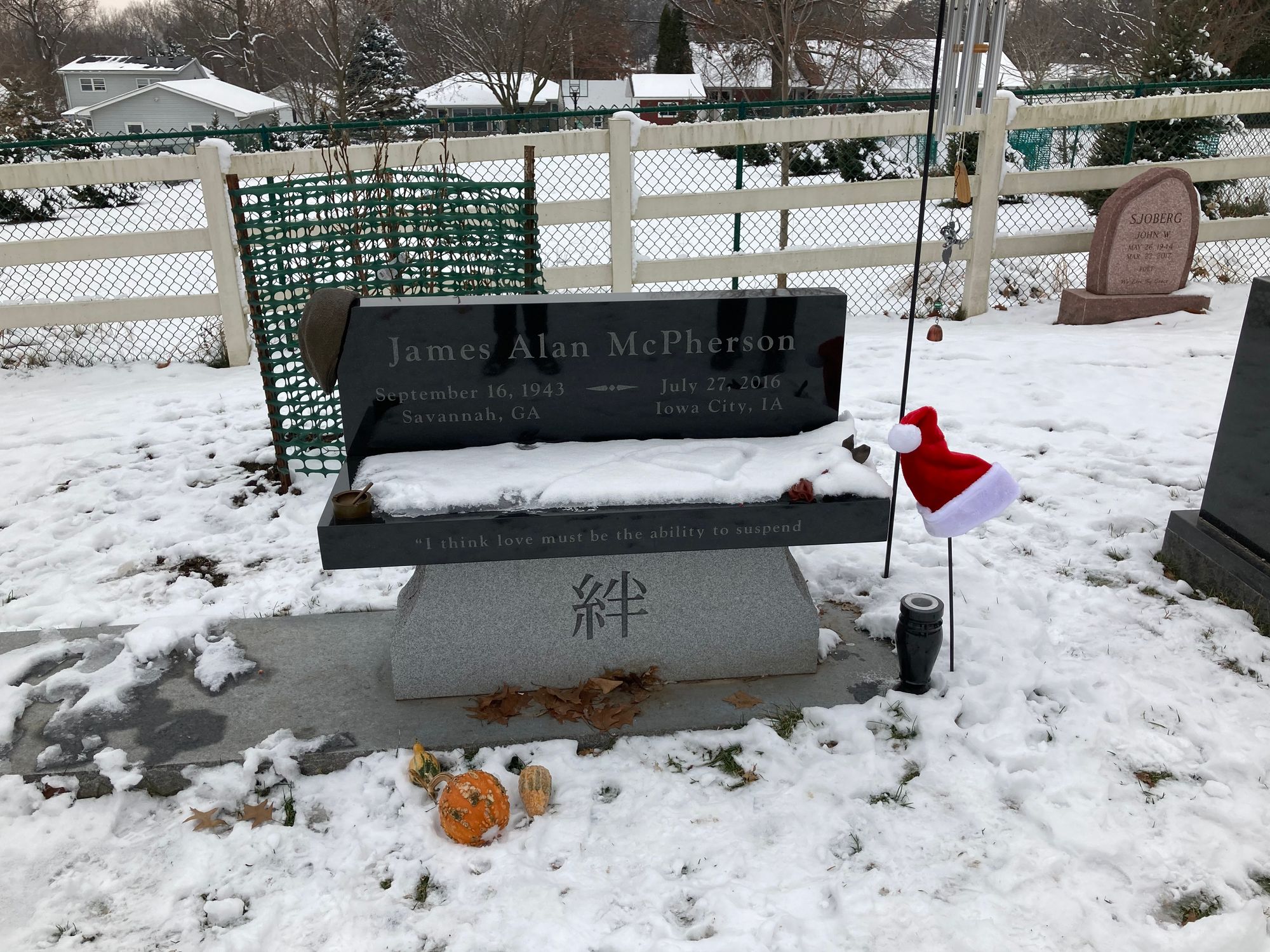 A black headstone surrounded by snow