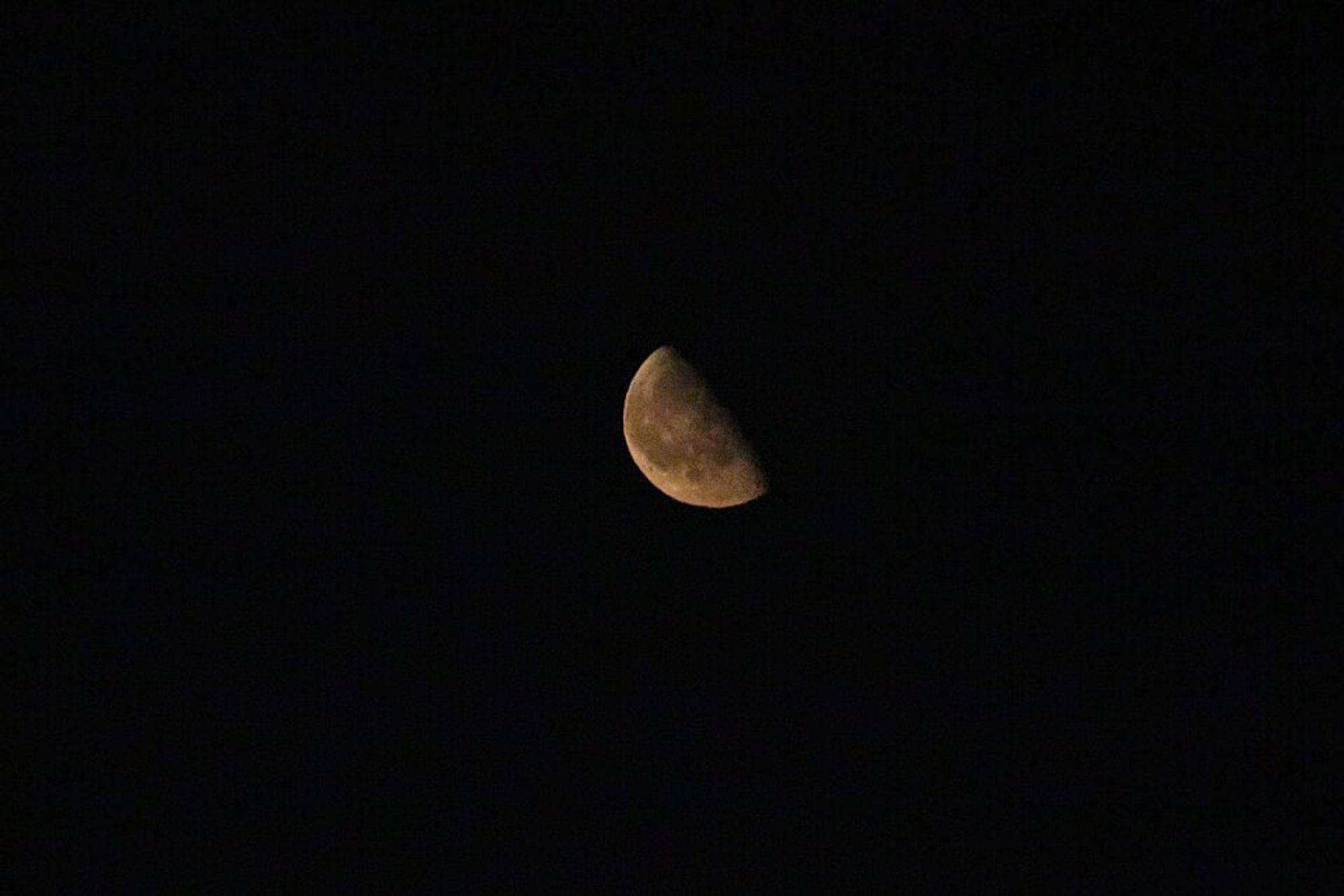 Black space with a quarter moon at the center.