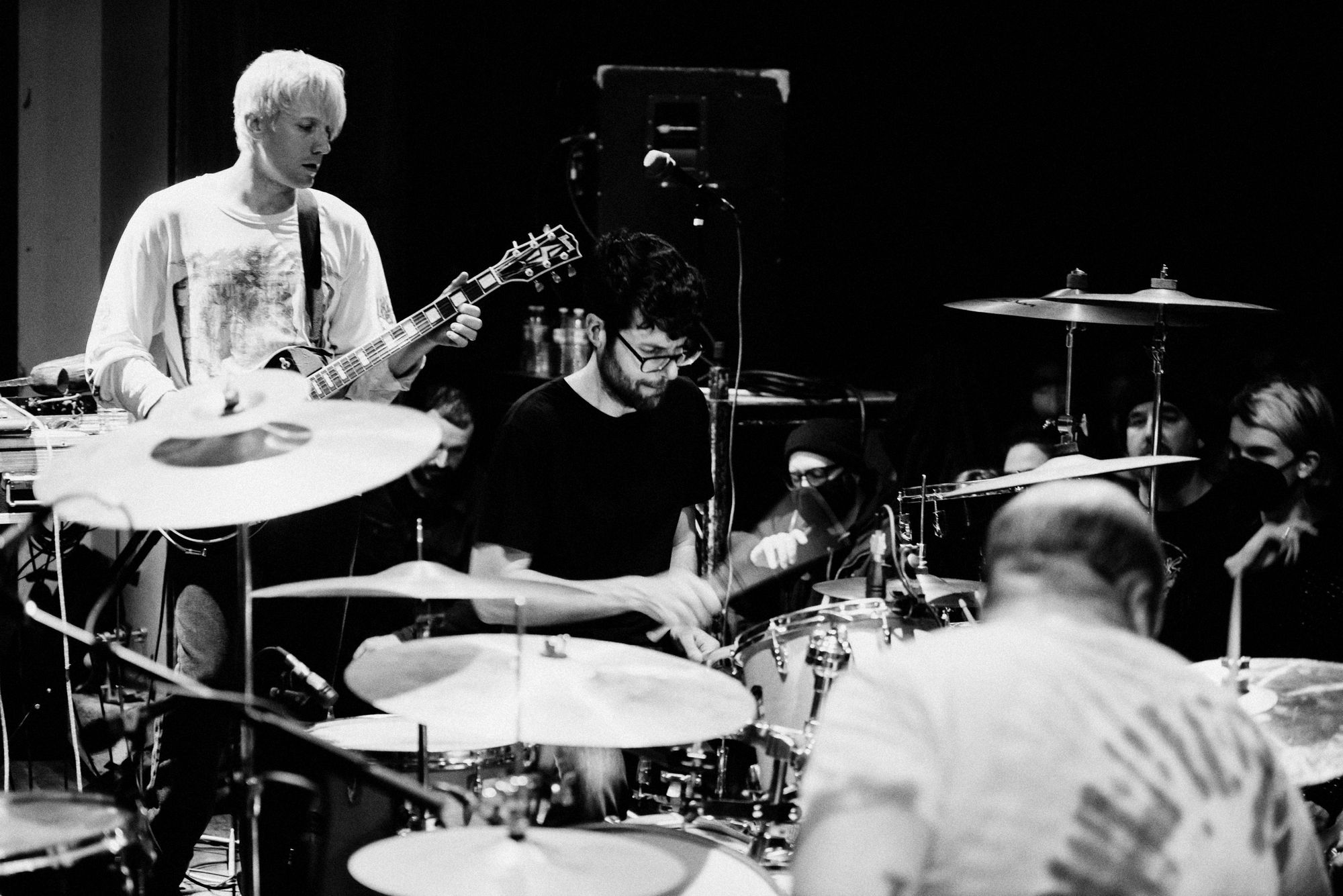 Black and white image of a punk band mid-performance.