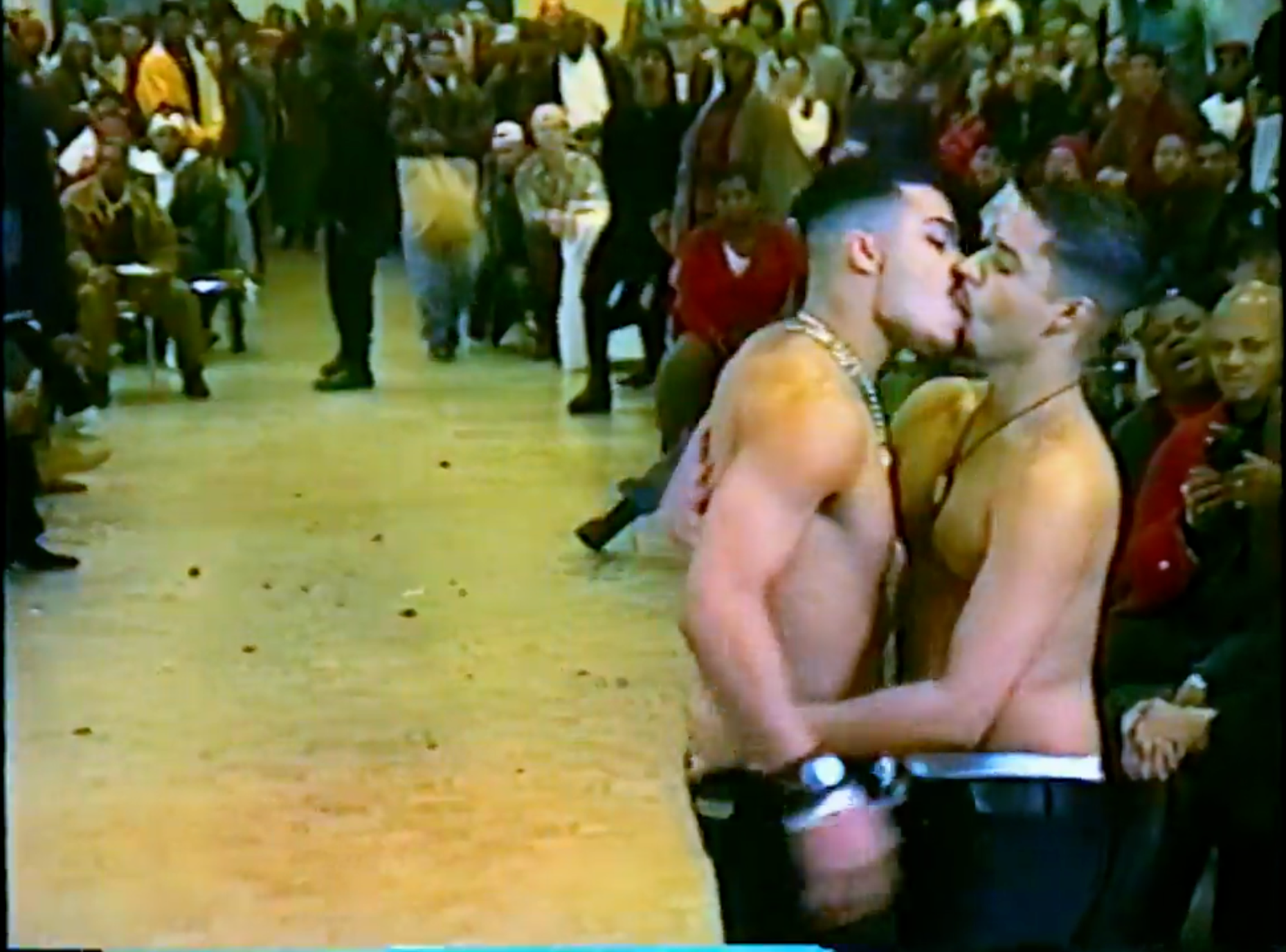 Two men kissing at a ballroom show