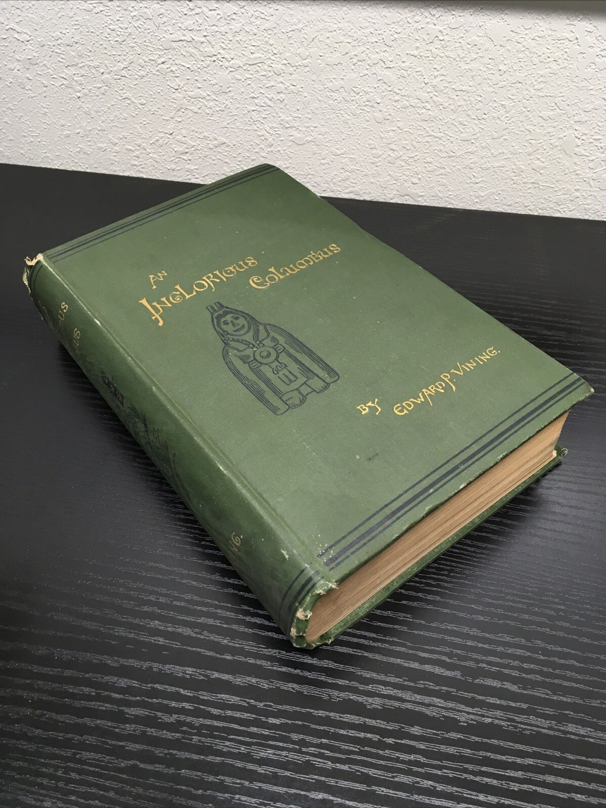 Thick, hard-cover green book on a table.