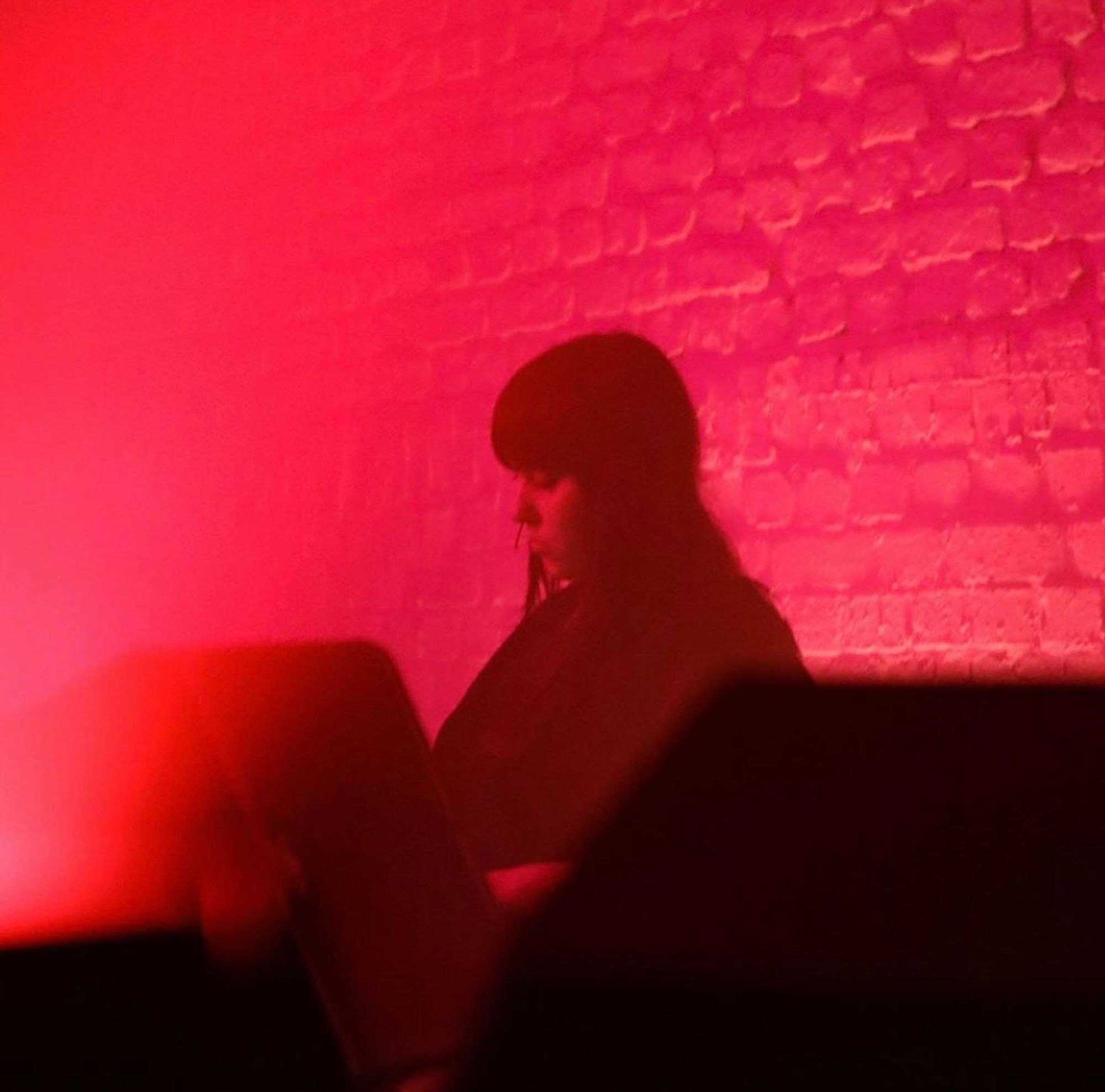 Ciarra Black performing, the photo is bathed in a red ambient haze