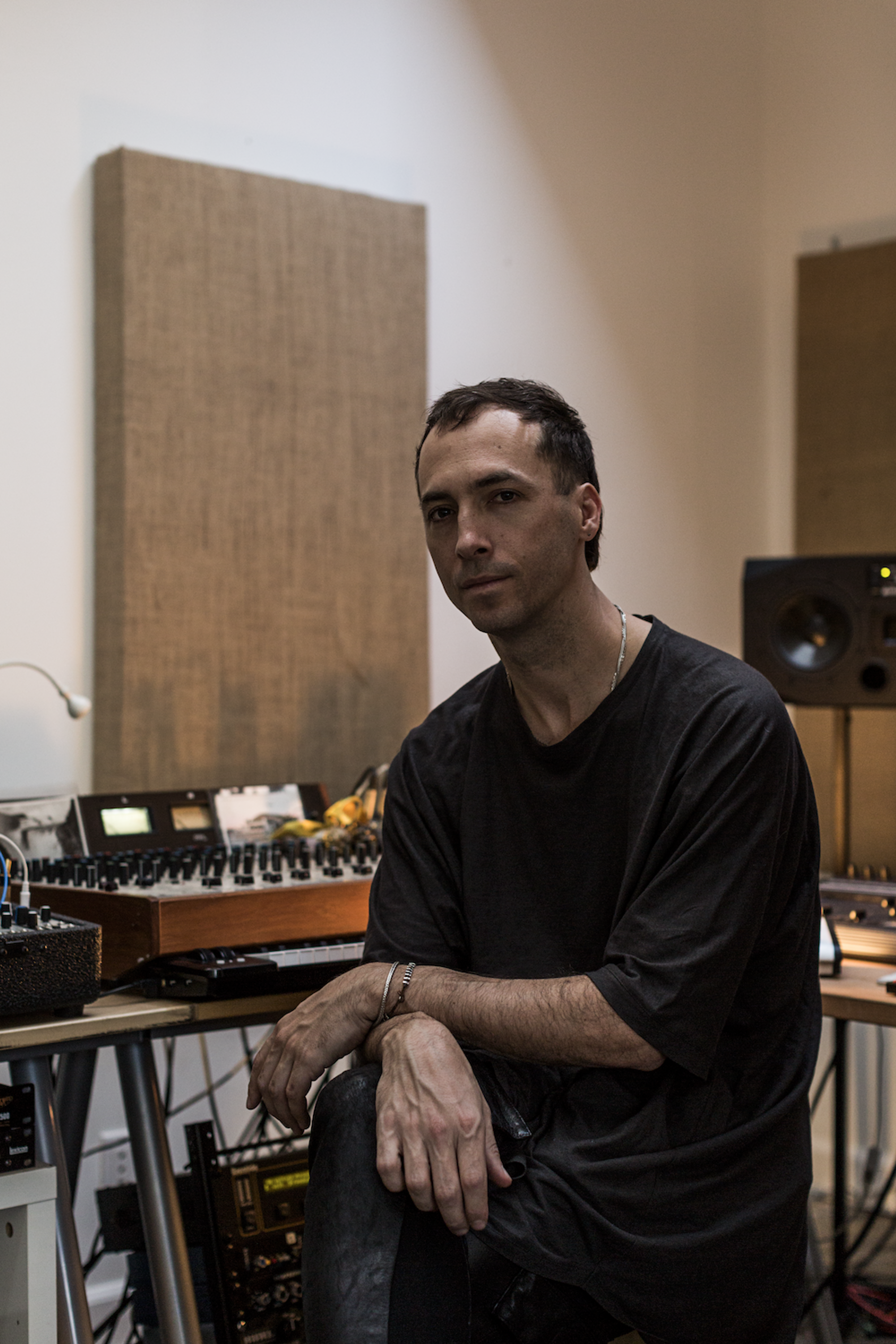 Tim Hecker in a music studio wearing a black shirt