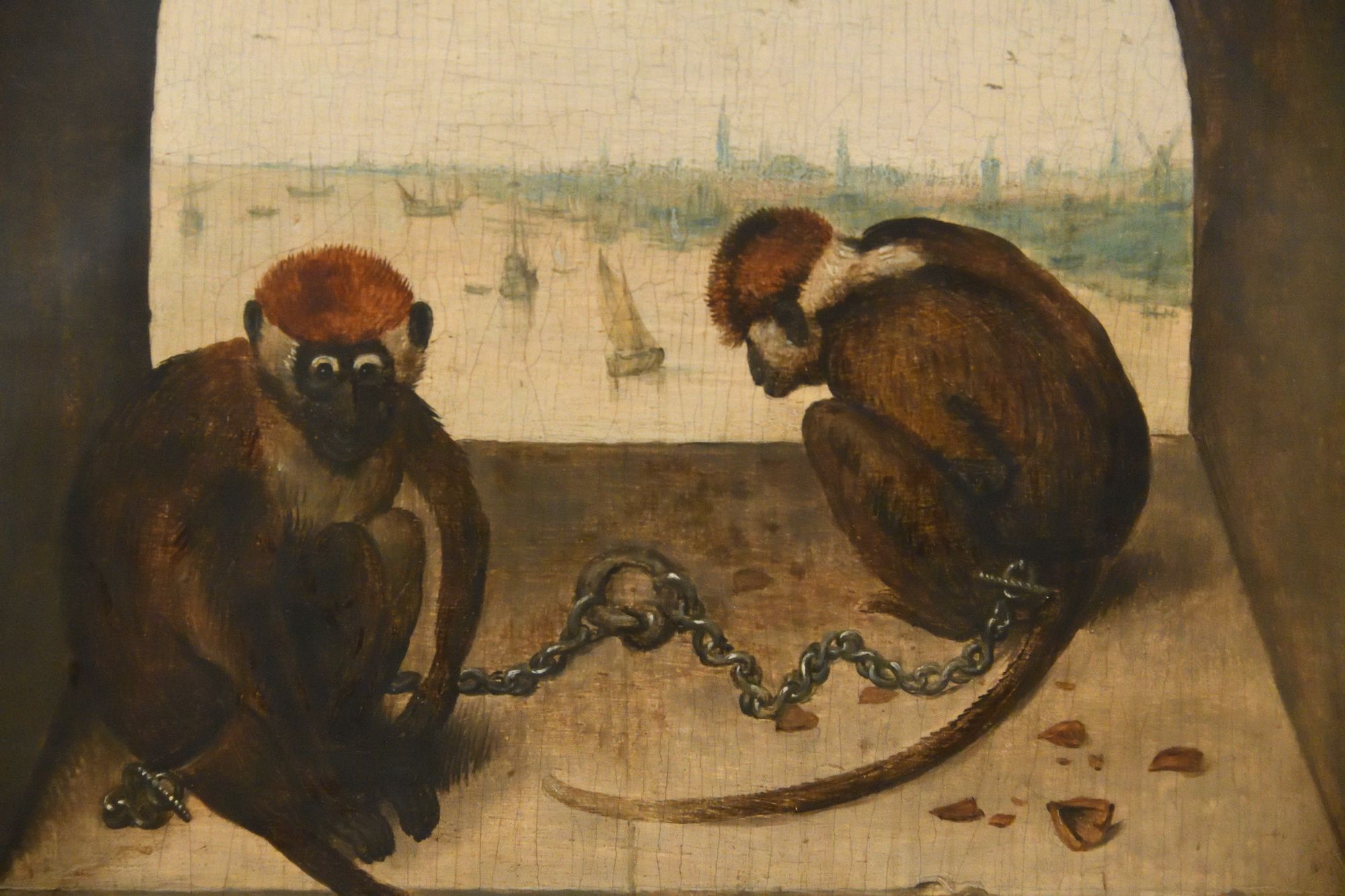 A painting of two chained monkeys, overlooking a port full of boats.
