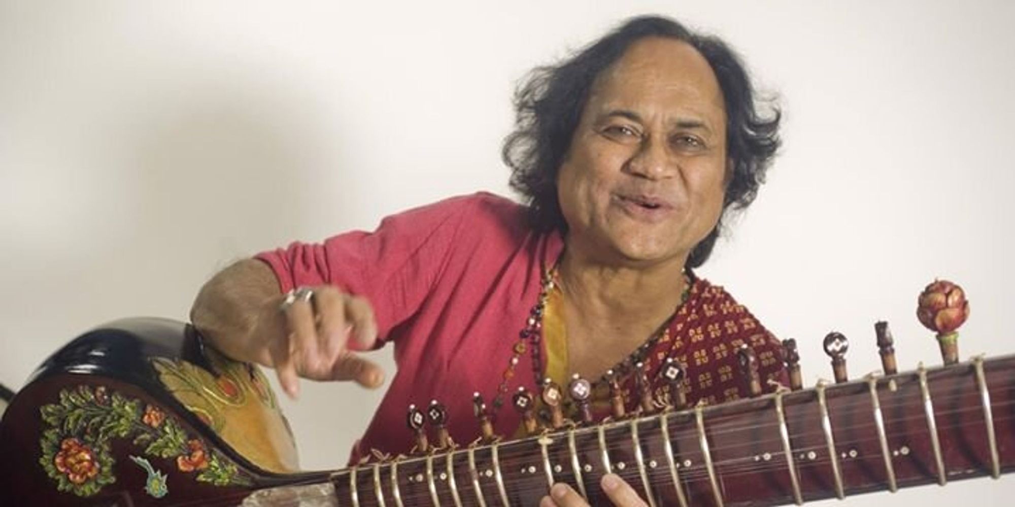 Khishna Mohan Bhatt, musician sitting and smiling 