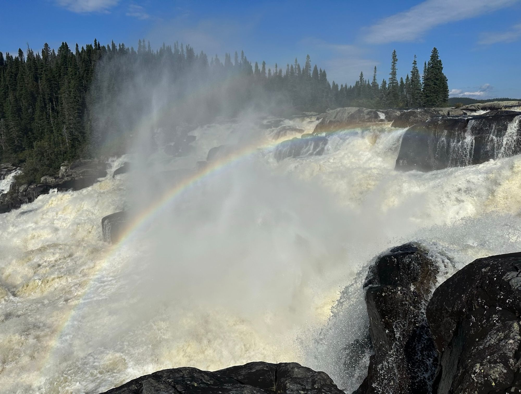 A rainbow rising over a waterfall.