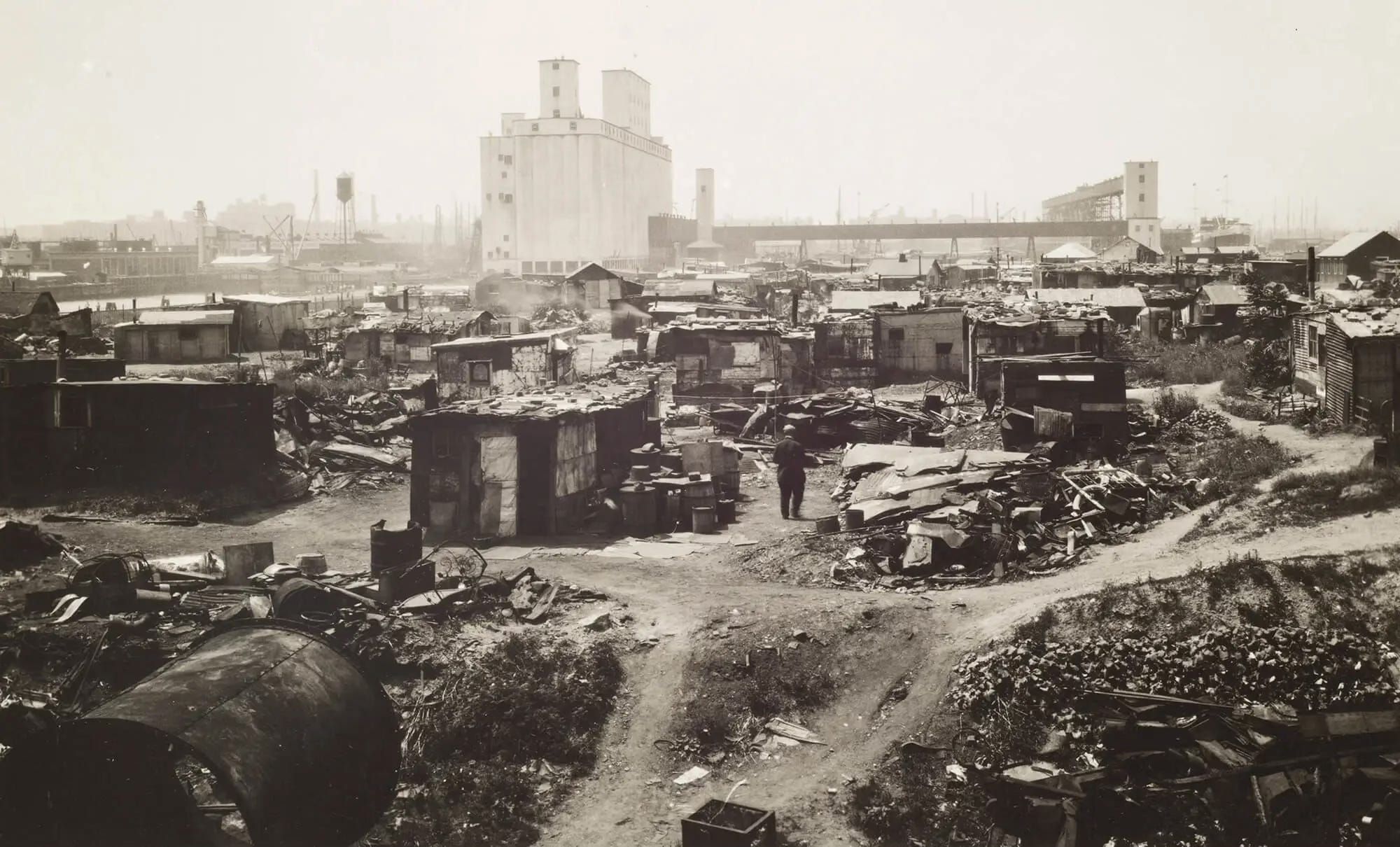 Photographic print showing the land now occupied by Red Hook Ball Fields, public pool, and NYCHA housing, with the grain terminal visible in the background. 
