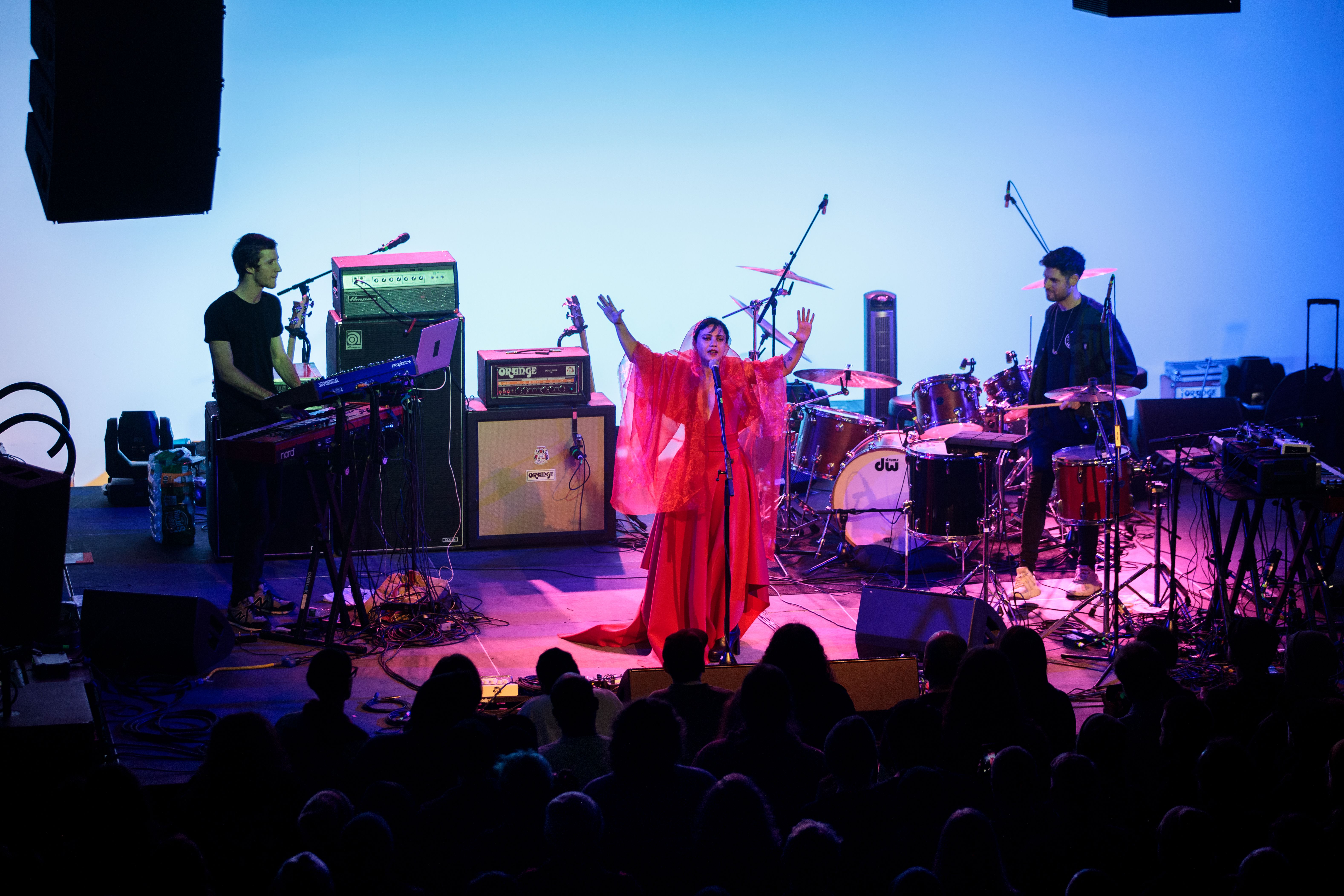 picture of emel with a black cape on and red background