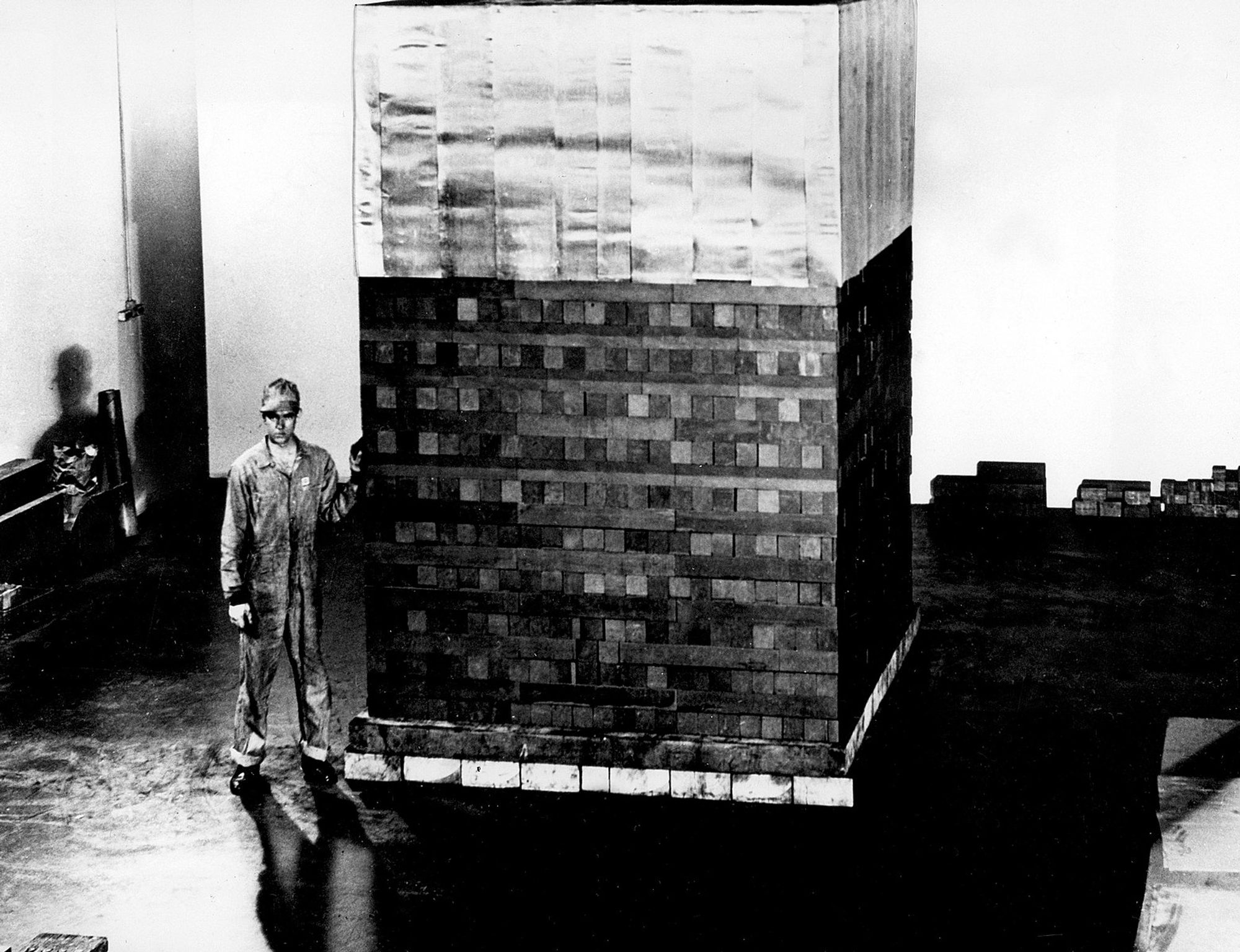 A man standing next a pile of bricks
