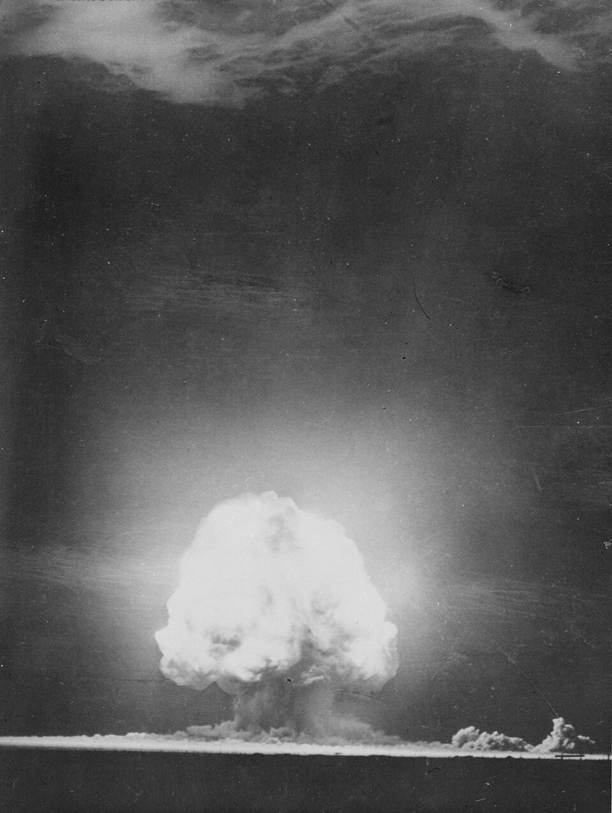 Vertical photo of large, white clouds caused by a nuclear explosion.