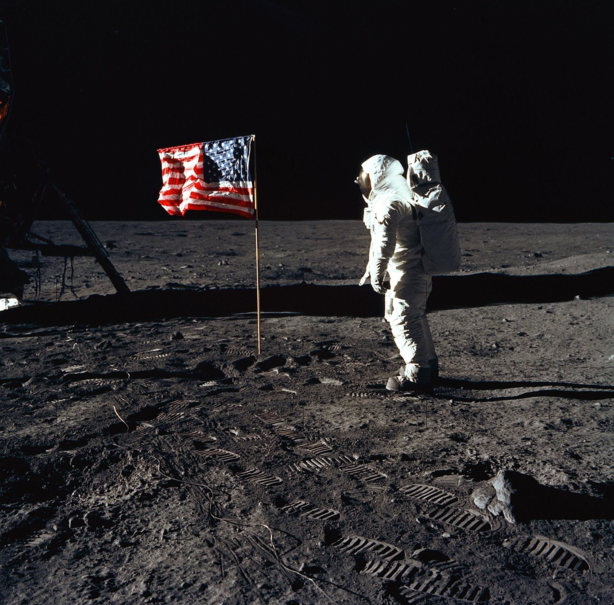 An astronaut on the moon posing with an American flag