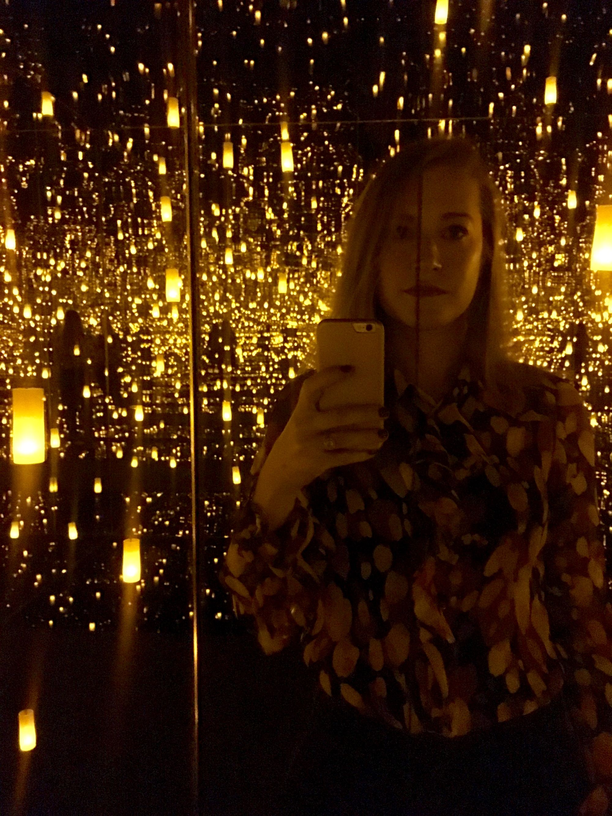 The author inside of a sparkle-filled installation by Yayoi Kusama