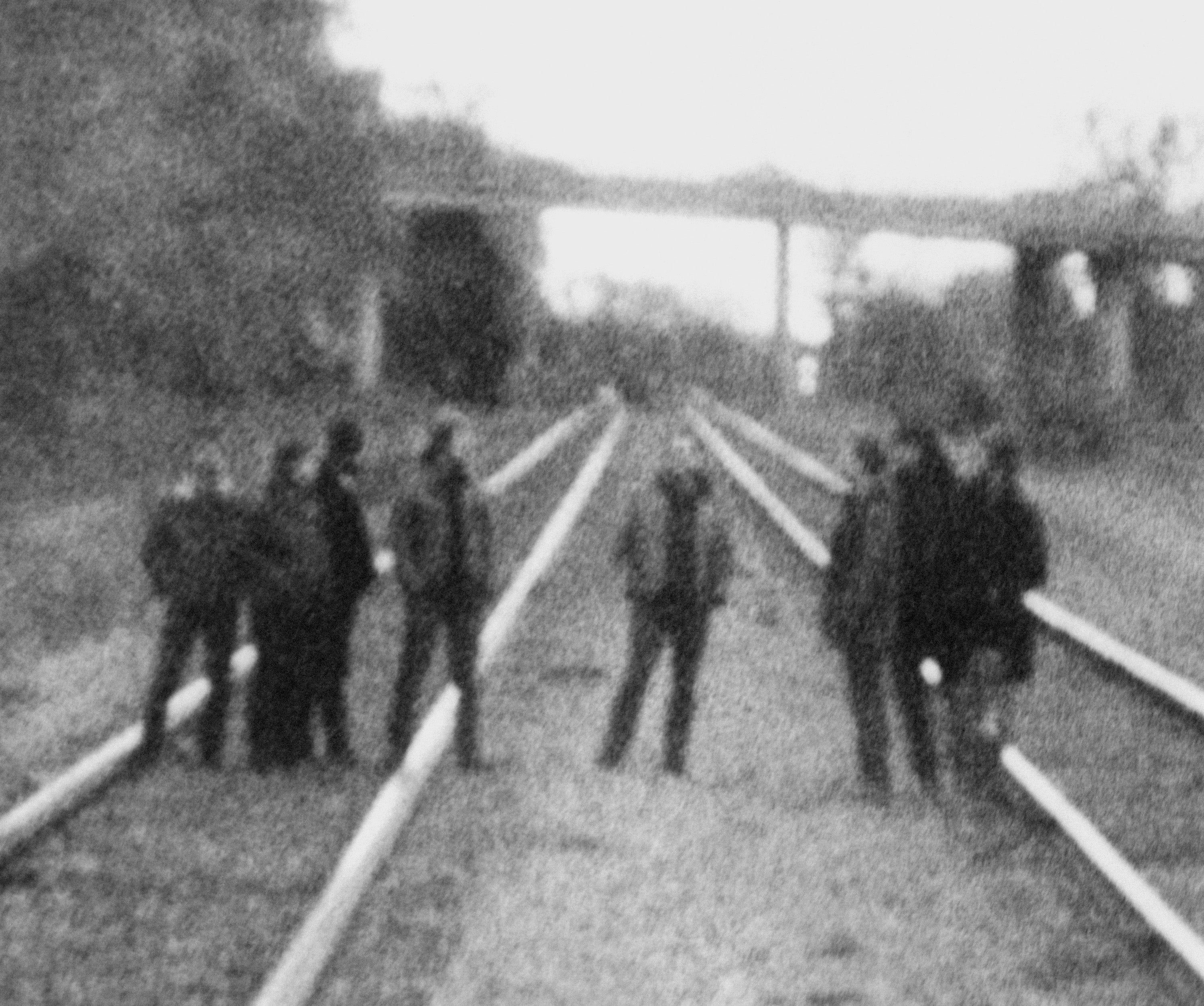 Blurry image of Godspeed You! on train tracks