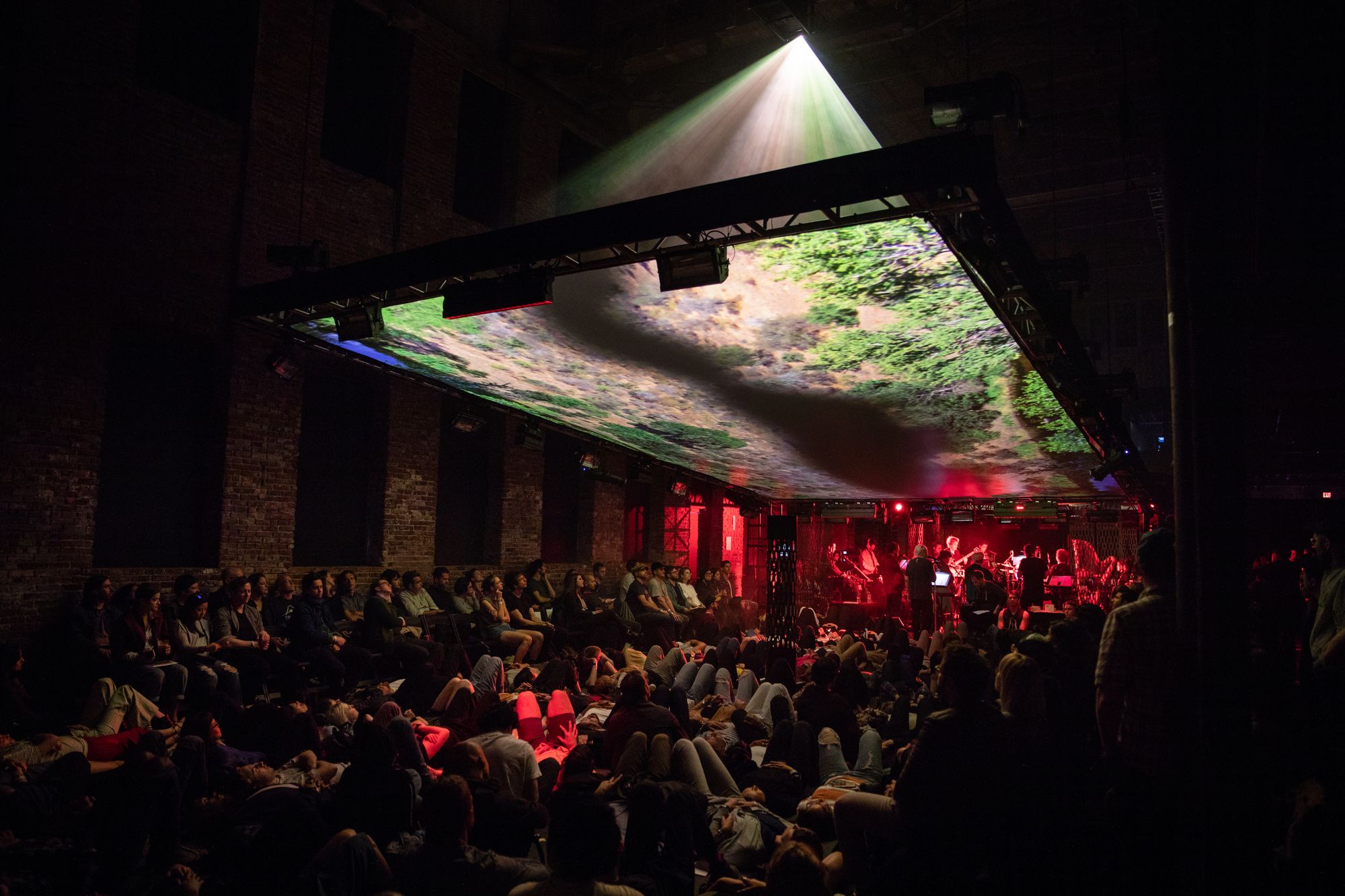 An audience below a projection screen